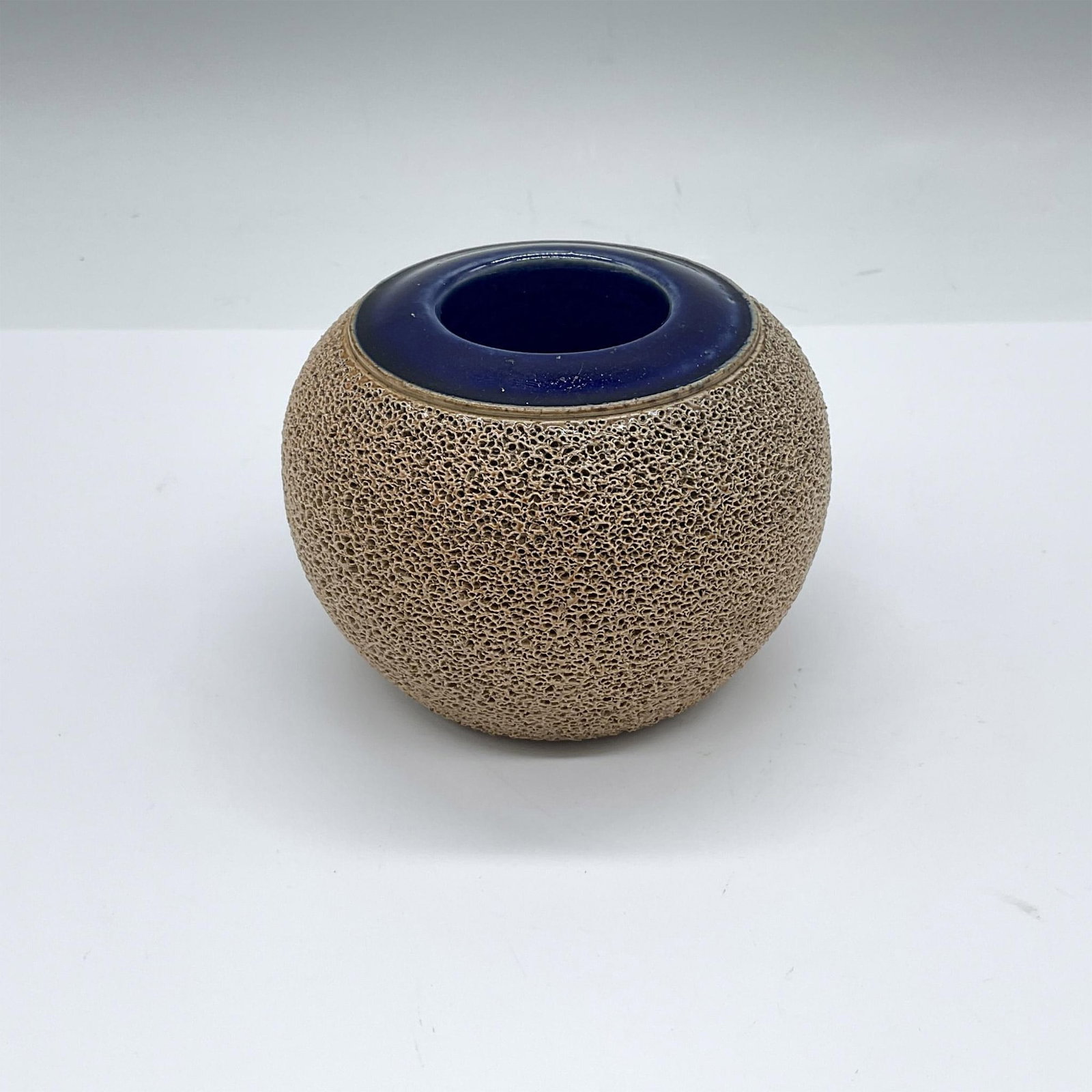 Royal Doulton Stoneware Matchstick Holder and Striker: A round ceramic match striker, with a blue glaze pocket to store matchsticks. Royal Doulton impressed stamp. Issued: 1922-1956 Dimensions: 3.75"W x 2.75"H Manufacturer: Royal Doulton Country of Origin