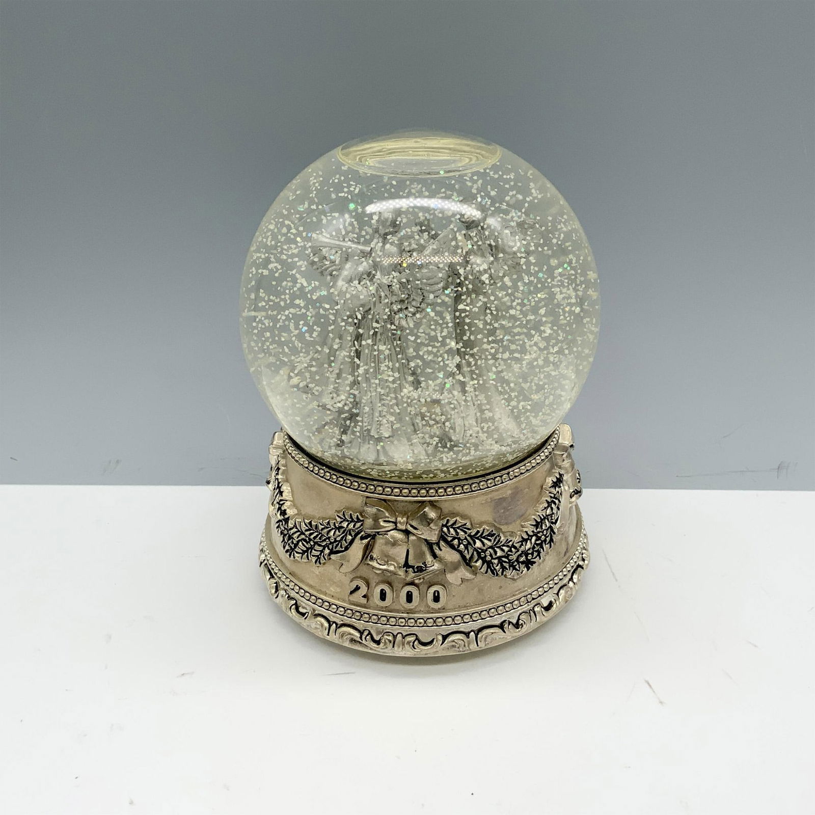Wallace Silversmiths Christmas 2000 Musical Angel Snow Globe: Beautiful glass globe containing three detailed angel figures with a silverplated base. Wallace Silversmiths backstamp on base. This item has its original box 6.5"L x 6.5"W x 7.75"H. Issued: 2000s Dim