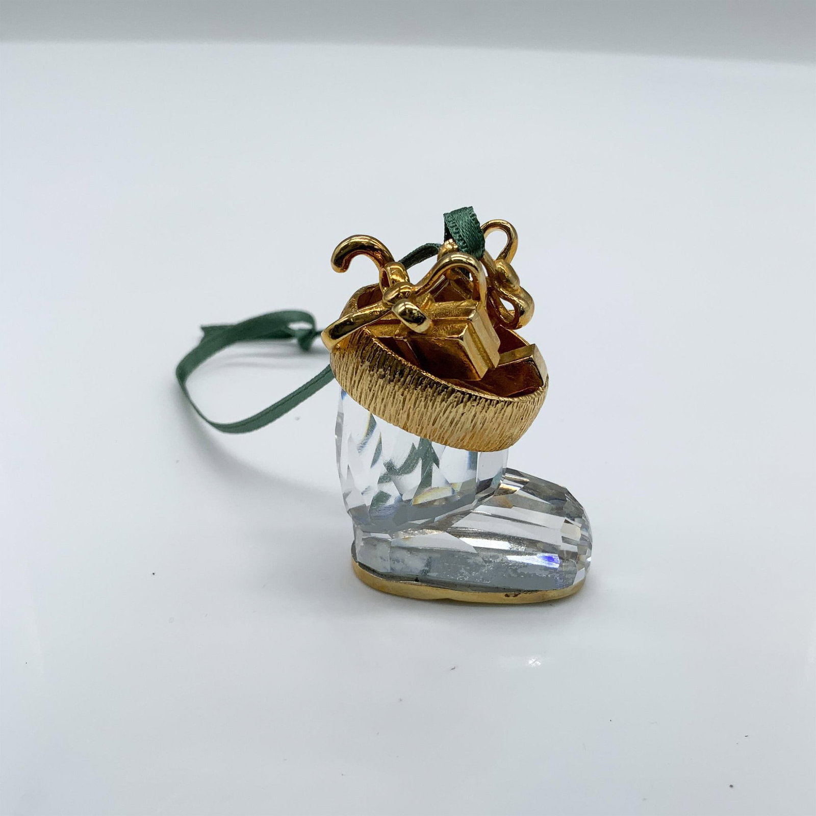 Swarovski Crystal Christmas Ornament, Boot 203078: This retired Winter snow boot stuffed with gifts ornament was part of the Christmas Memories theme grouping. It is clear faceted crystal with gold metal accents. It comes in its original box, which me