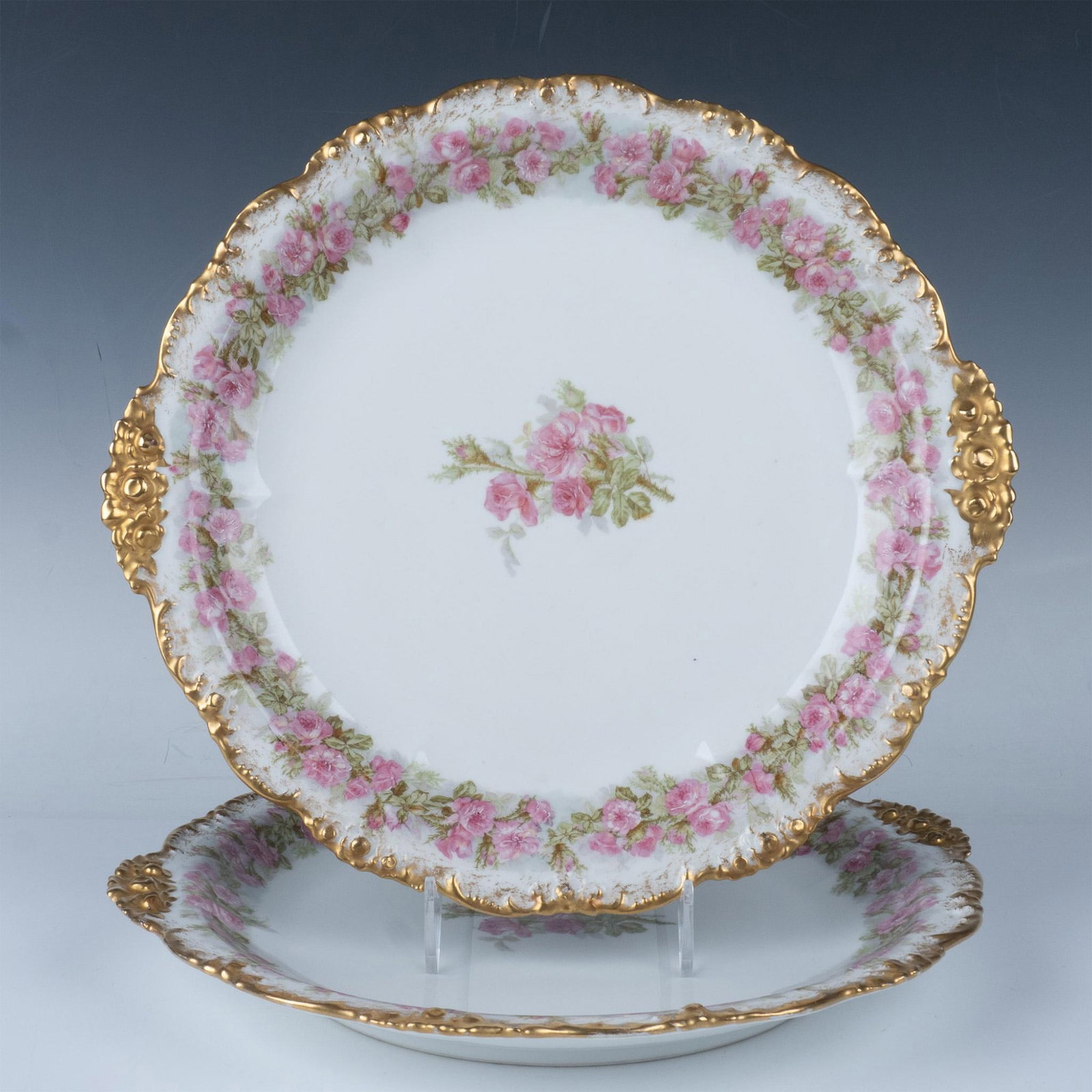 2pc Jean Pouyat Limoges Porcelain Rose Platters: Lovely gilt handled and edged platters with lovely rose pattern along rim. J Pouyat Limoges backstamp. Issued: 20th century Dimensions: 14"L x 13"W x 1.5"H Manufacturer: Jean Pouyat Limoges Country of