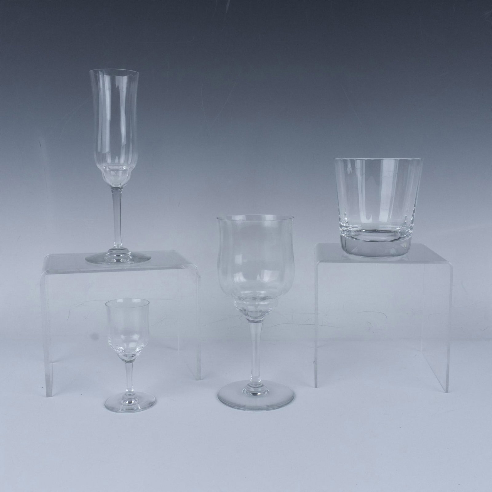 4pc Baccarat Crystal Capri Optic Glassware: Clear crystal drinkware with smooth vertical lines. The collection includes a lowball glass, a cordial glass, a champagne flute and a wine glass. Each is marked with Baccarat etched marking. Lowball: 