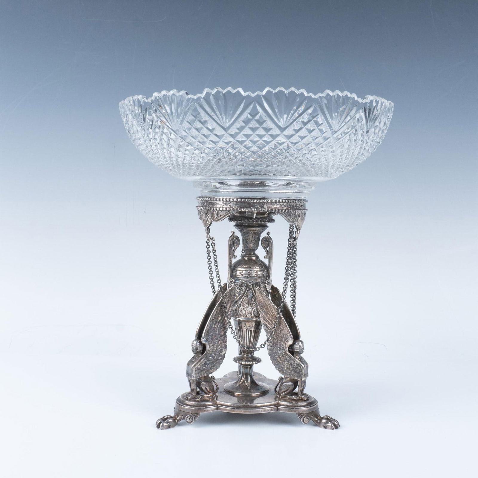 2pc Frederick Elkington Sterling Silver Egyptian Garniture: An Egyptian revival. A stunning trefoil-shaped sterling silver base on raised paws. Perched on the corners are winged sphinxes. The center column is in an urn shape adorned in a classical acanthus des