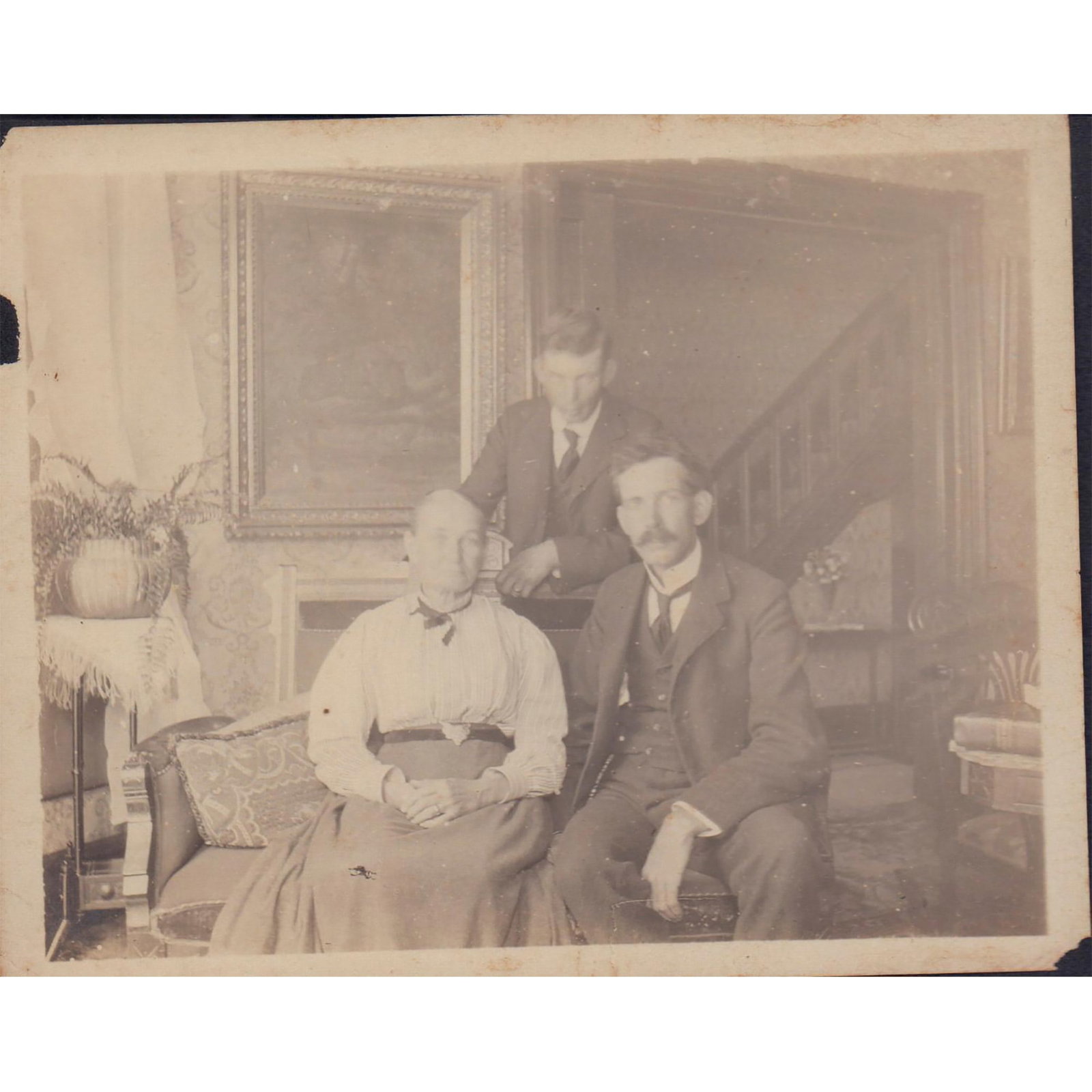 Antique Black and White Group Photo: An indoor group photo of two men and one woman posing for the photo inside a finely decorated room. Dimensions: 5"W x 4"H