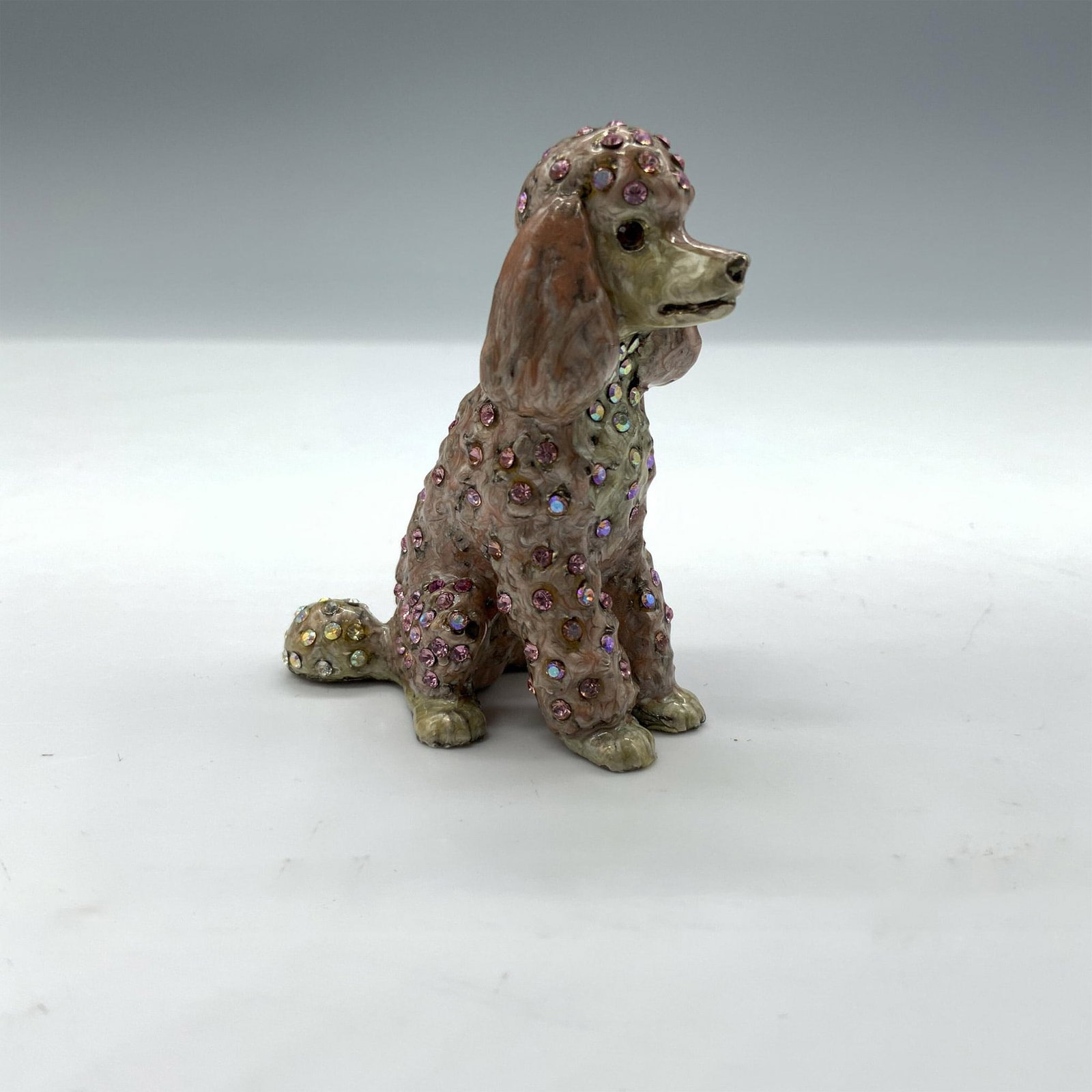 Jay Strongwater Pink Poodle Dog Figurine: Beautiful miniature dog figurine featuring enamel with pink and iridescent crystals. Jay Strongwater stamp on the bottom. Dimensions: 2"L x 1"W x 2"H Manufacturer: Jay Strongwater Country of Origin: U