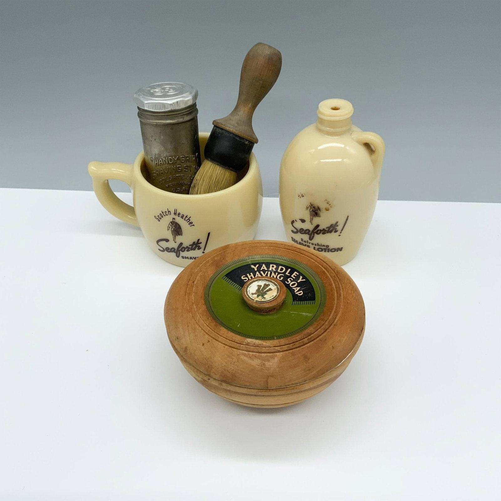 5pc Seaforth and Yardley Shave Set: Vintage collection consisting of a Seaforth shaving mug and shave lotion jug, a Yardley shaving soap container, a Colgate shaving stick container, and a Rubberset shaving brush. Largest item measures 