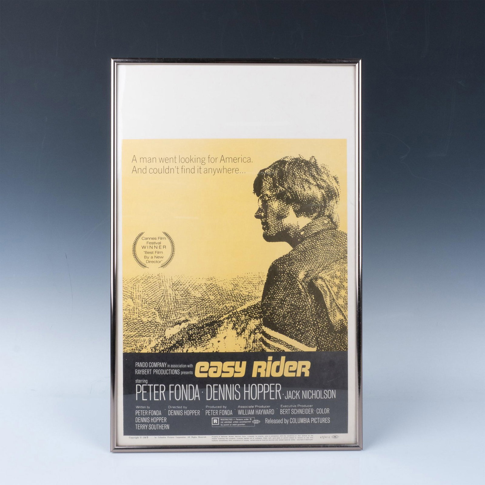 Theatrical Edition Poster of Easy Rider: Collectible poster of the movie Easy Rider edition number 69 of 202 printed on the lower right corner of the paper. Frame dimensions: 14.25"L x 22.25"H x 1"D. Image dimensions: 13.5"L x 21.5"H. Issued