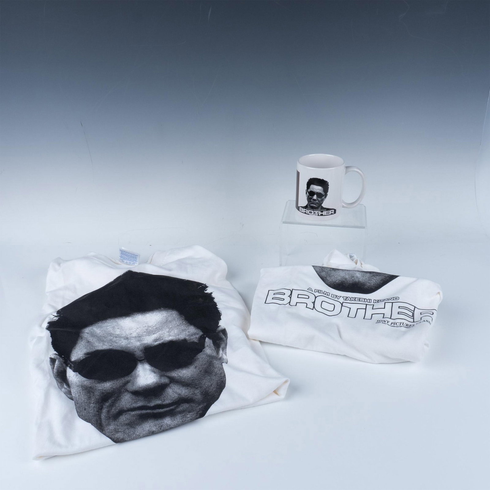 3pc Brother by Takeshi Kitano Movie Merchandise: 2 XL white T shirts and a thermal coffee mug featuring the character Yamamoto from the movie Brother, with the mug revealing a bullet hole wall design when hot. Dimensions of the largest item: 5"L x 3