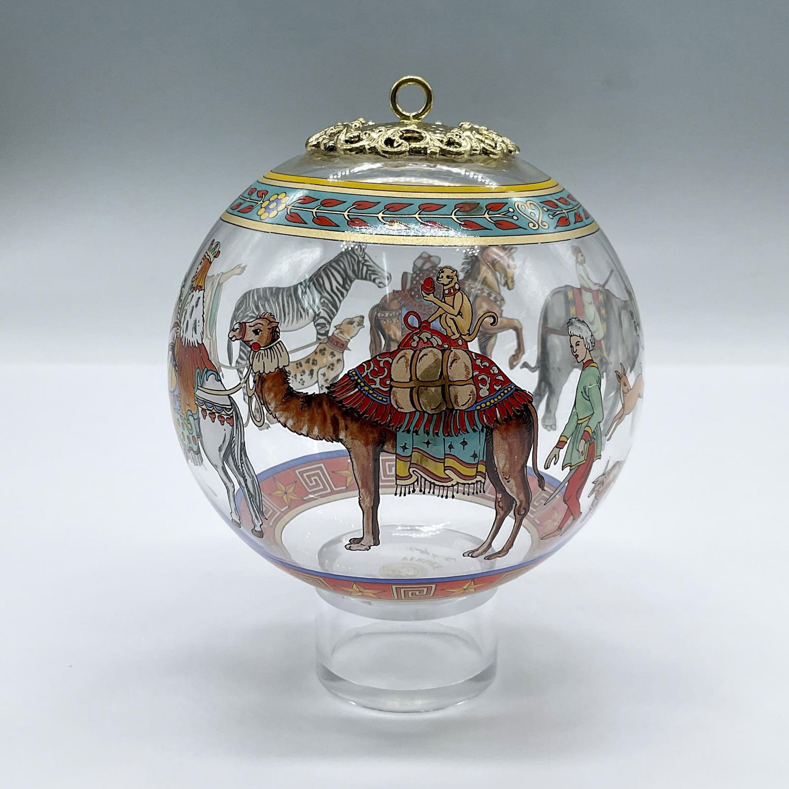 Rosenthal Versace Cortege De Noel Glaskugel Ornament: This exquisite glass ball Christmas ornament showcases a captivating scene of a Christmas procession, adorned 24k gold gilding at the crown. This item has its original box measuring, 5.75"L x 5.75"W x