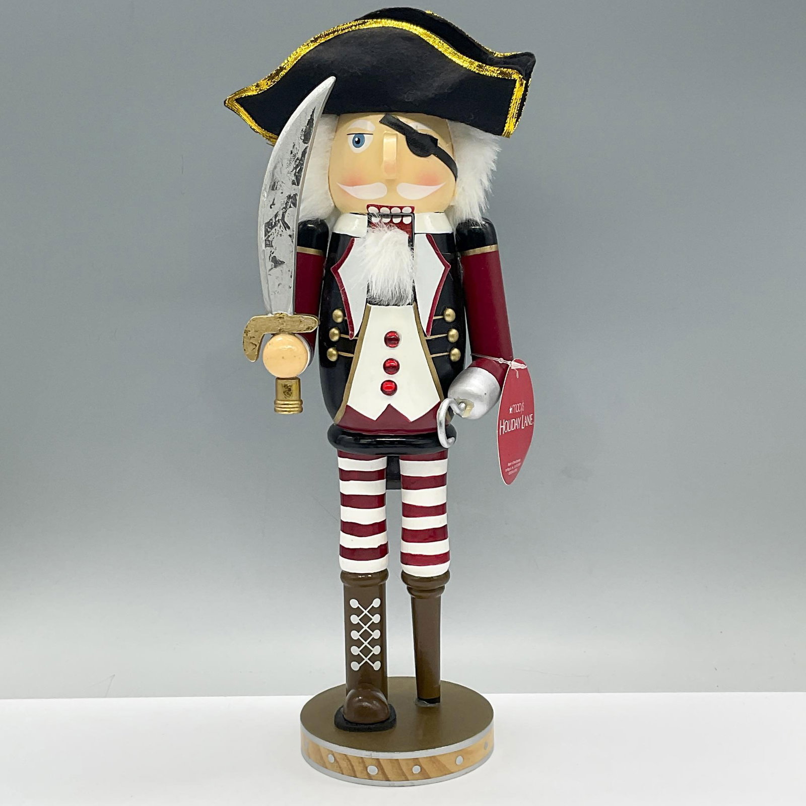 Macys Holiday Lane Wooden Nutcracker: Ahoy Matey! This charming Pirate Nutcracker is equipped with a sword, a hook and peg leg. Tag reads, Macy's Holliday Lane. Dimensions: 5.25"L x 4.75"W x 14.5"H
