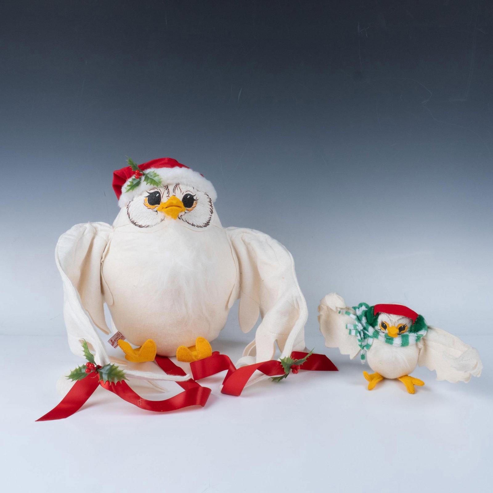 Pair of Annalee Holiday Owls: Adorable set of birds with their wings spread that consists of a large owl wearing a hat and holiday berries, and a smaller owl with a striped green scarf. Annalee tag on both items. Largest item meas