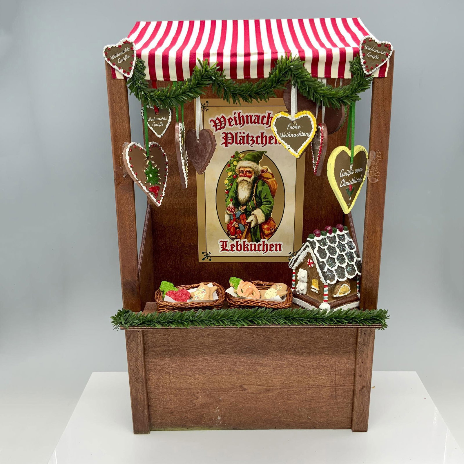 Byers Choice Gingerbread Vendor Market Stall: Stunning wooden booth with a red and white striped tarp that is decorated with Christmas decor and cookies. Byers Choice backstamp on base. Issued: 2014 Dimensions: 11"L x 7"W x 18.25"H Manufacturer: 