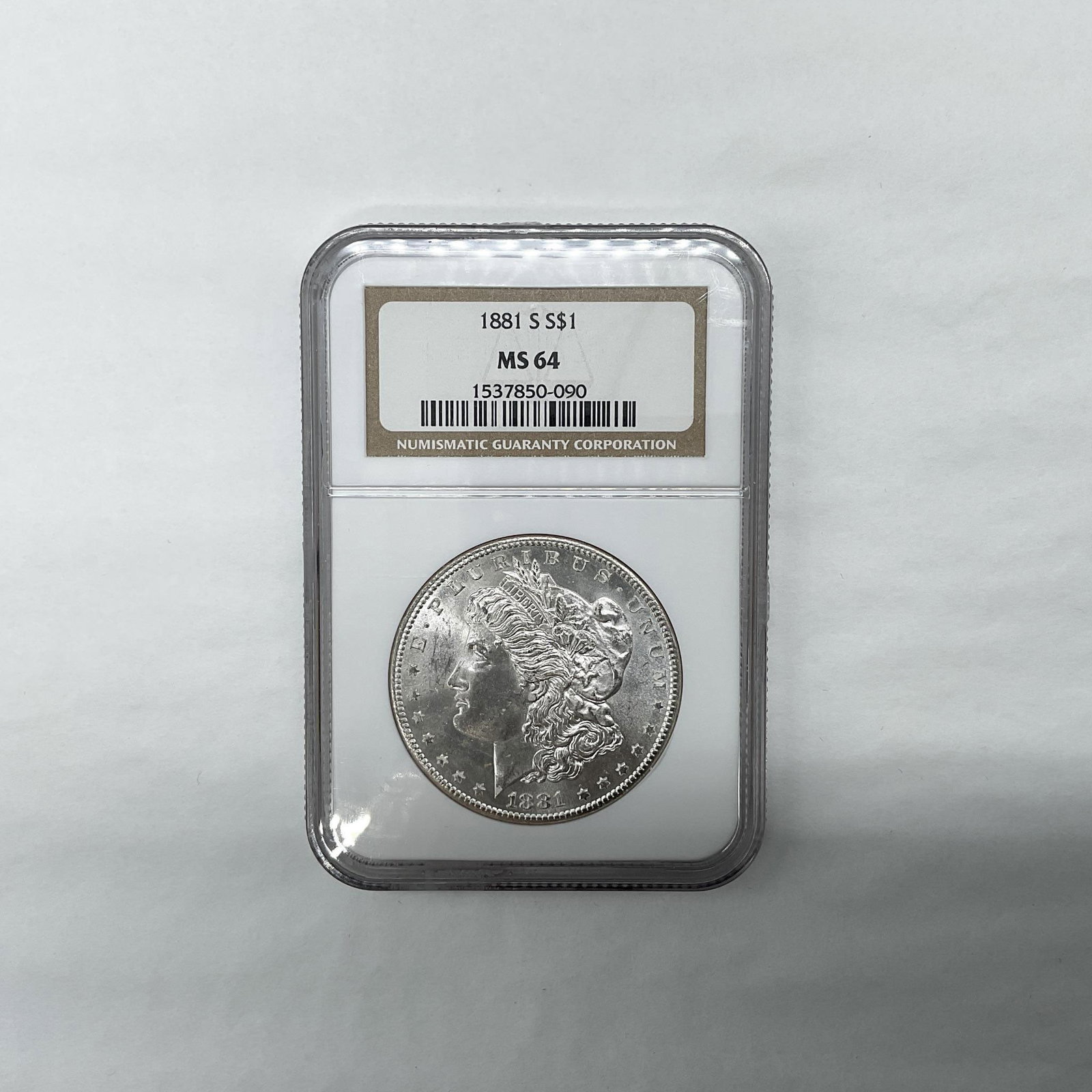 1881-S Morgan Silver Dollar NGC Graded MS64: San Francisco Mint. The obverse side features Liberty in profile. She is shown in cap, flora, and crown. The reverse side depicts an eagle with outstretched wings gripping arrows and an olive branch. 