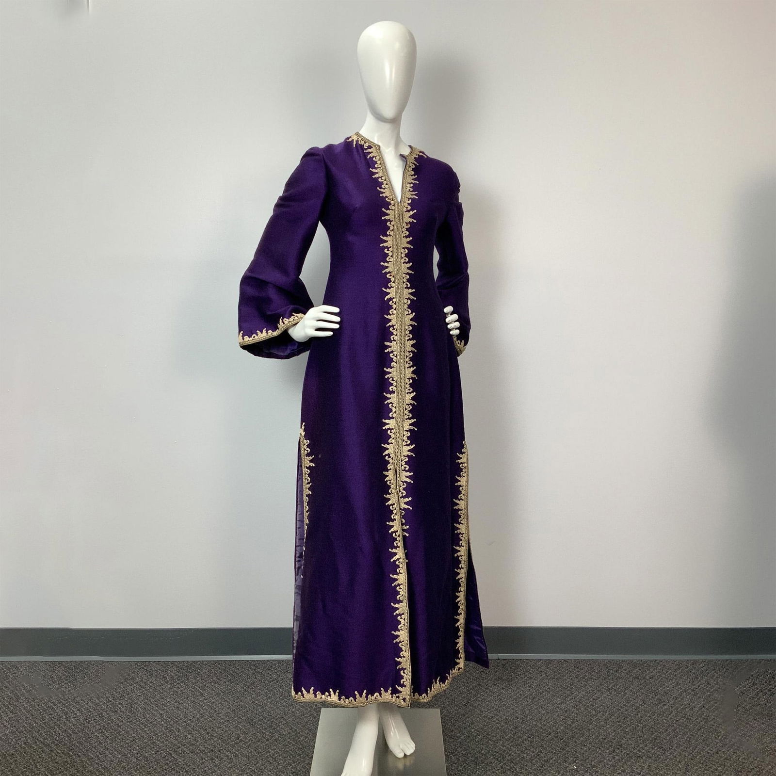 La Greca Purple Linen Weave Caftan: Full length Purple linen weave Caftan. Corded ivory and gold embroidery outlining the entire dress. The sleeves are 3/4 length with a bell shape. The long Body has mirrored side 25" slits, center fron