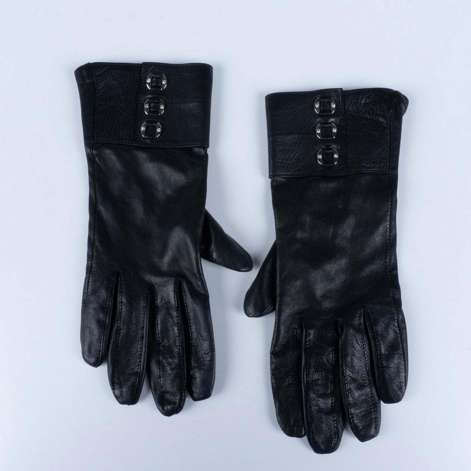 Pair of Vintage Guy Laroche Leather Women's Gloves, Size 8: Soft black leather fabric lined. Wrist cuff embellished with silver tone hardware and hand stitched hem. Guy Laroche tag. Issued: 20th century Dimensions: 10"L x 3.5"W Manufacturer: Guy Larouche Count