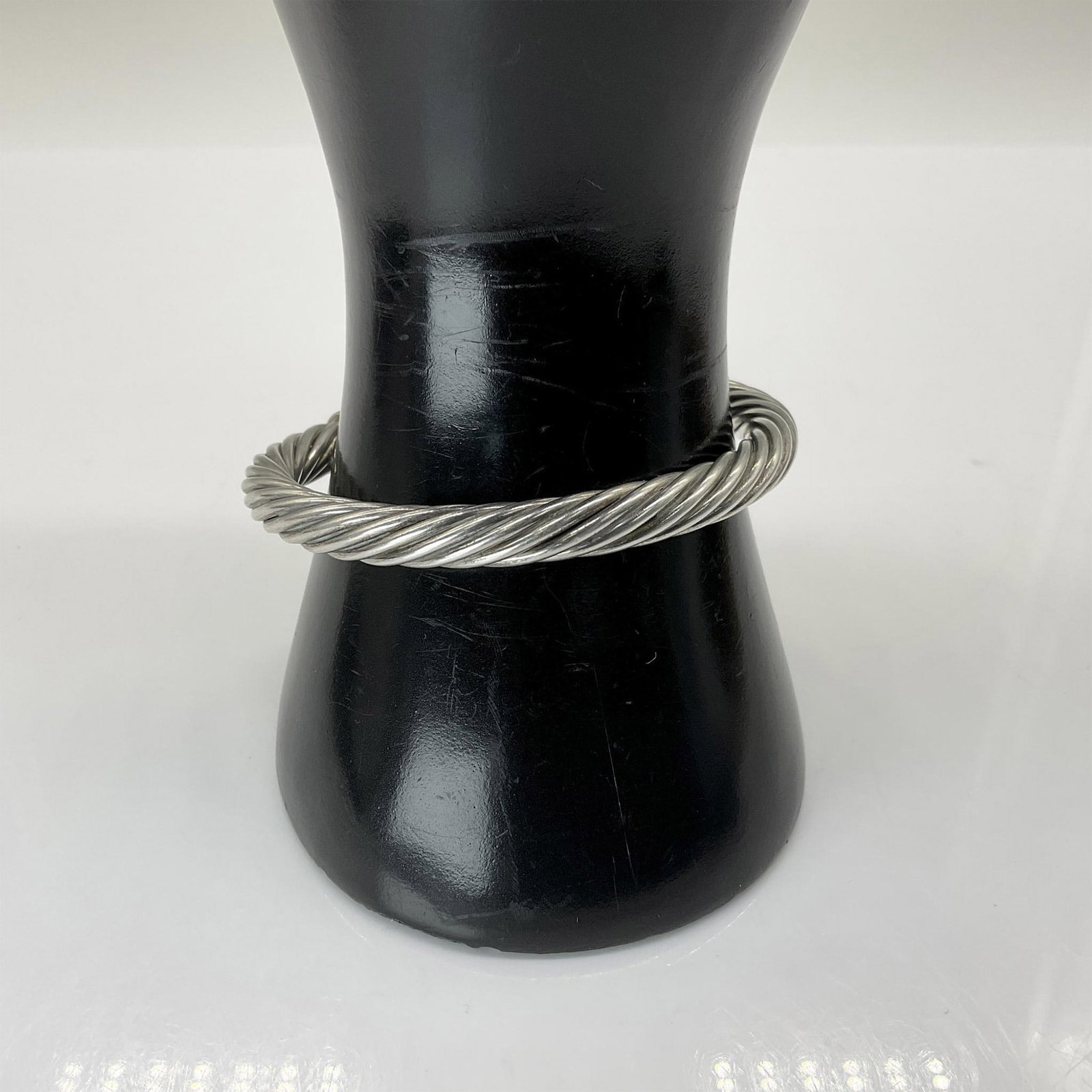 David Yurman Style Twisted Metal Bracelet: Twisted silver toned rope bracelet with purple crystal terminations. Marked 925 ND. Measures 7.5" from end to end. Total weight is 20 grams. Dimensions: See Description