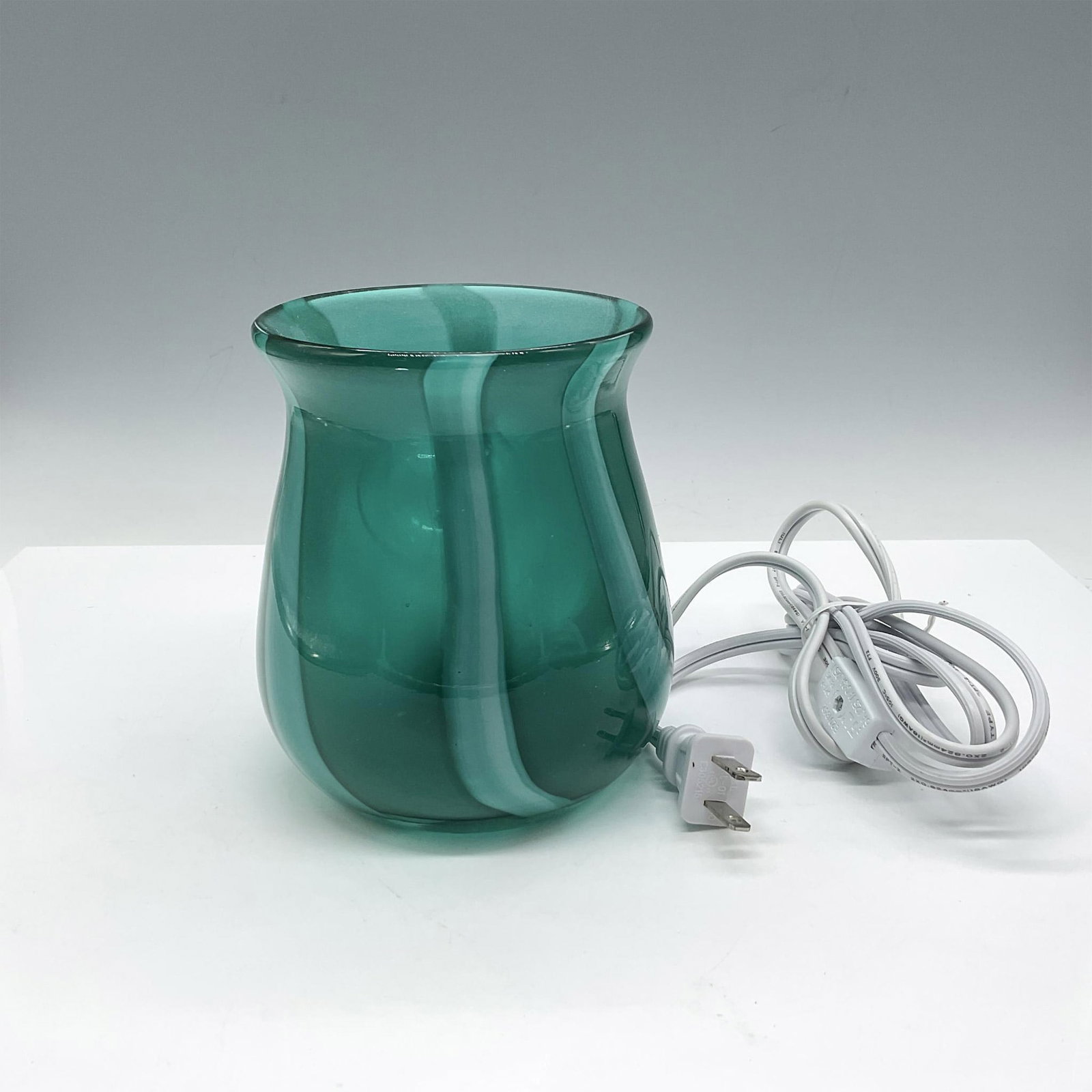 Art Glass Modern Table Lamp: Emerald, green swirled glass around center bulb. Twist switch on cord. Felt cover on base. Issued: 21st century Dimensions: 5.5"H x 5" dia.