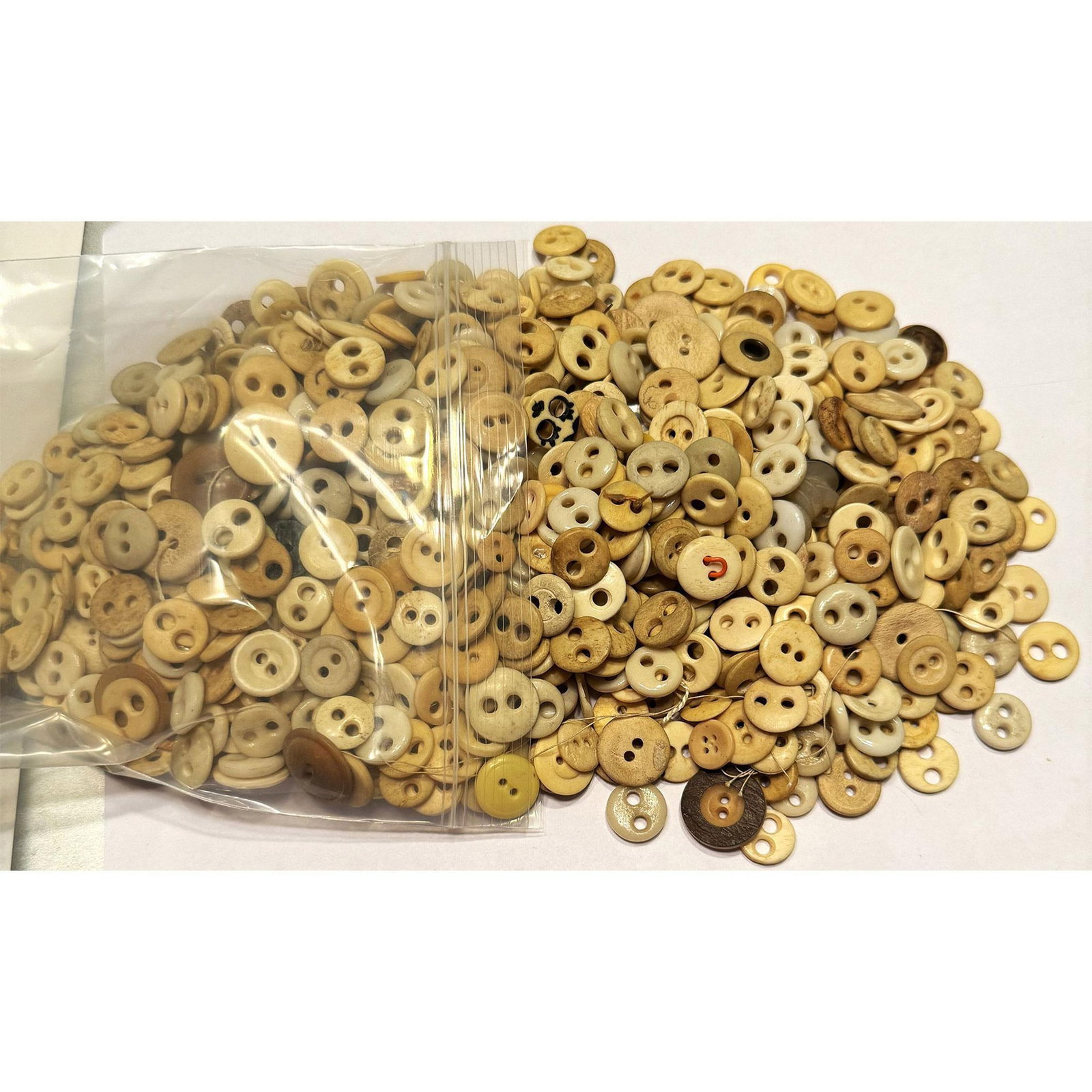 A large assortment of natural material buttons: A bag full of bone underwear buttons from the 18th & 19th C. These little underwear buttons are quite earthy and have always had a kind of aura about them in the button collecting world. Many in the p