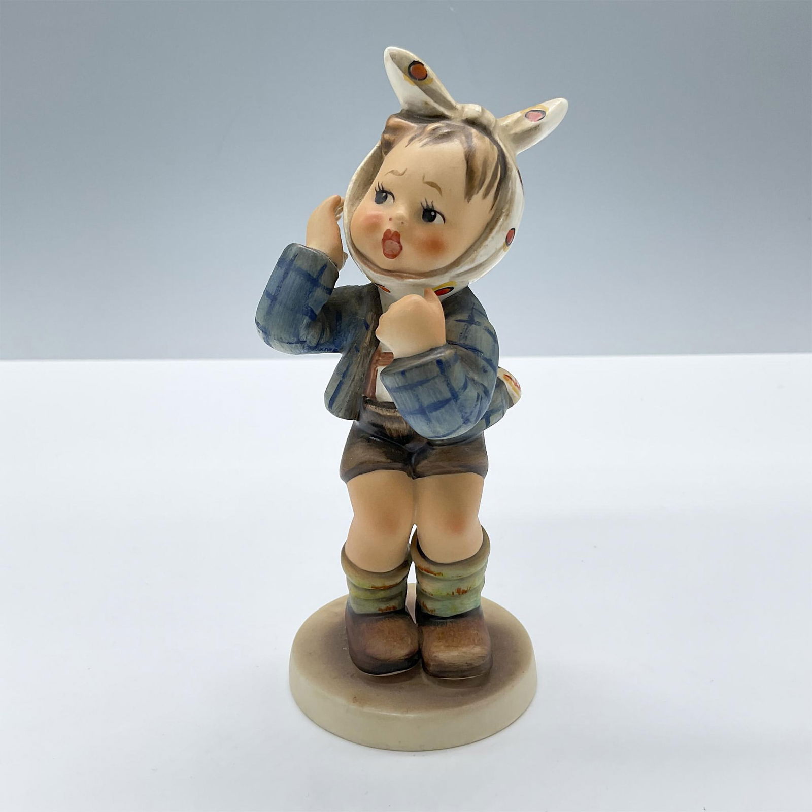 Goebel Hummel Figurine, Boy with Toothache 217: Features a boy modeled in a blue jacket and brown pants, with his head wrapped in a cloth. Goebel Hummel backstamp. Issued: 20th century Dimensions: 5.5''H x 2.25''dia Manufacturer: Goebel Hummel Coun
