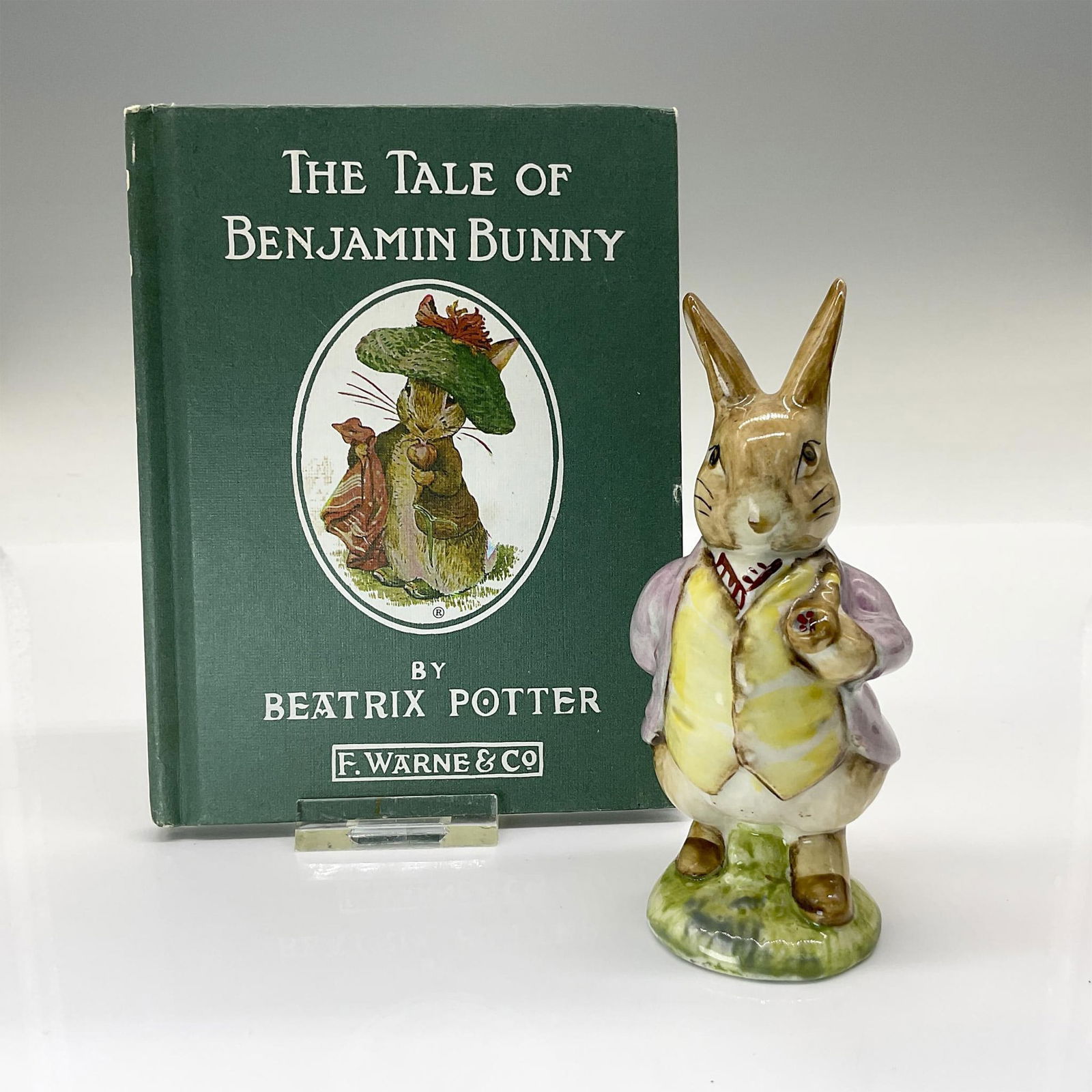 2pc Beswick Beatrix Potter Figurine & Benjamin Bunny Book: This figure of Benjamin Bunny with his pipe and wearing a lilac jacket. This item was issued 1970-2000. It features the Beswick backstamp. Measures 2"L x 2"W x 4.5"H. Additionally included is a hardco