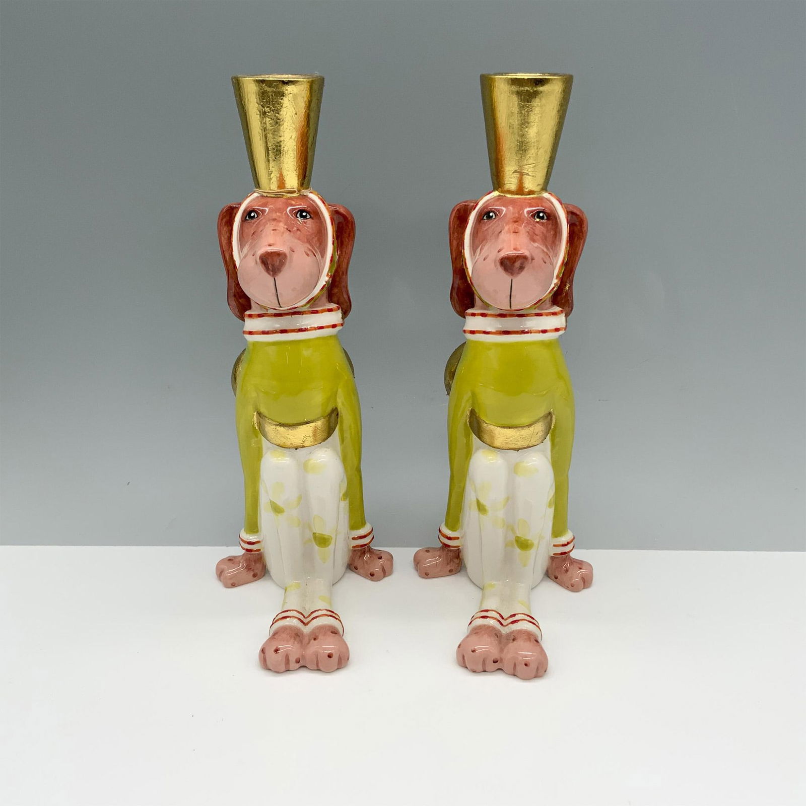 Pair of Patience Brewster Porcelain Dog Candle Holders: Marvelous duo of canines sitting down with bows around their waist as they wear candlestick holders on their heads. Patience Brewster backstamp. Issued: 20th century Dimensions: 3.25"L x 4.75"W x 9"H