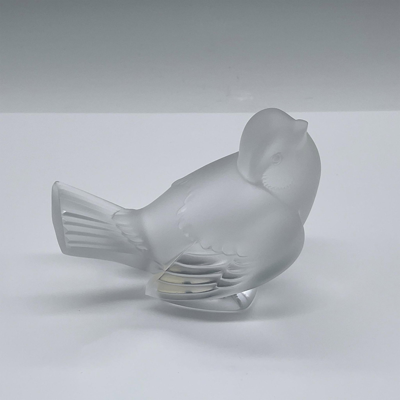 Lalique Crystal Bird Figurine: An adorable frosted, satin, crystal figure of a sparrow looking up. Lalique France etched on the back. Made In France sticker on the underside. Issued: 20th century Dimensions: 4.5"L x 2.5"W x 3.25"H 