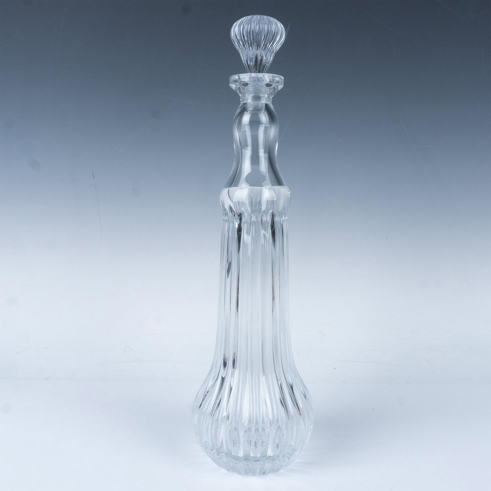 Global Views Glass Decanter with Stopper: Stunning tall and sleek glass decanter with long narrow body and neck accentuated with vertical ribbed design. Dimensions: 4.25"Dia. x 15.25"H Manufacturer: Global Views Country of Origin: United Stat