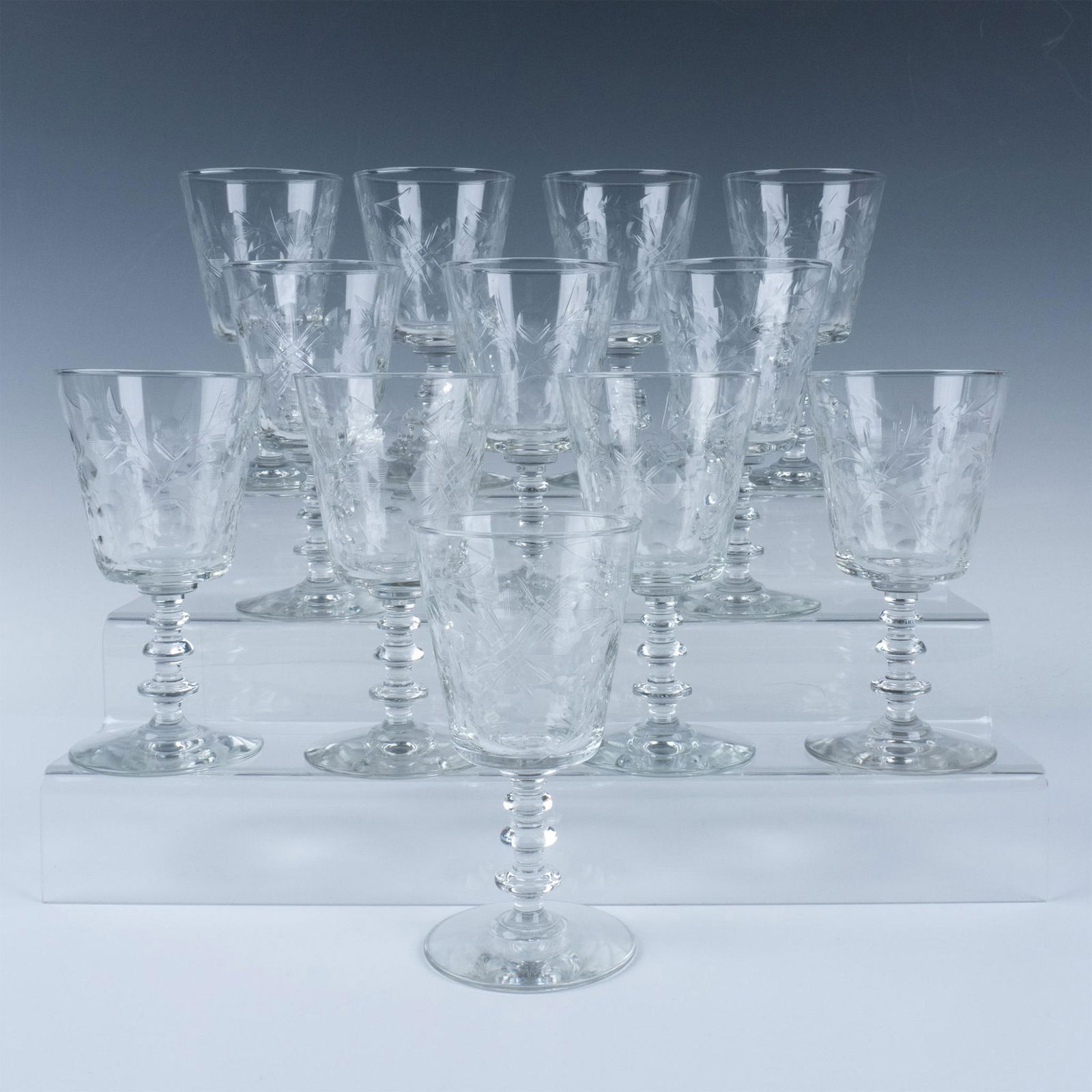 12pc Rock Sharpe Water Goblets: Beautiful floral motif on these etched glasses top a unique three-ring patterned stem. Issued: 20th century Dimensions: 6.5"H x 3.25"dia.