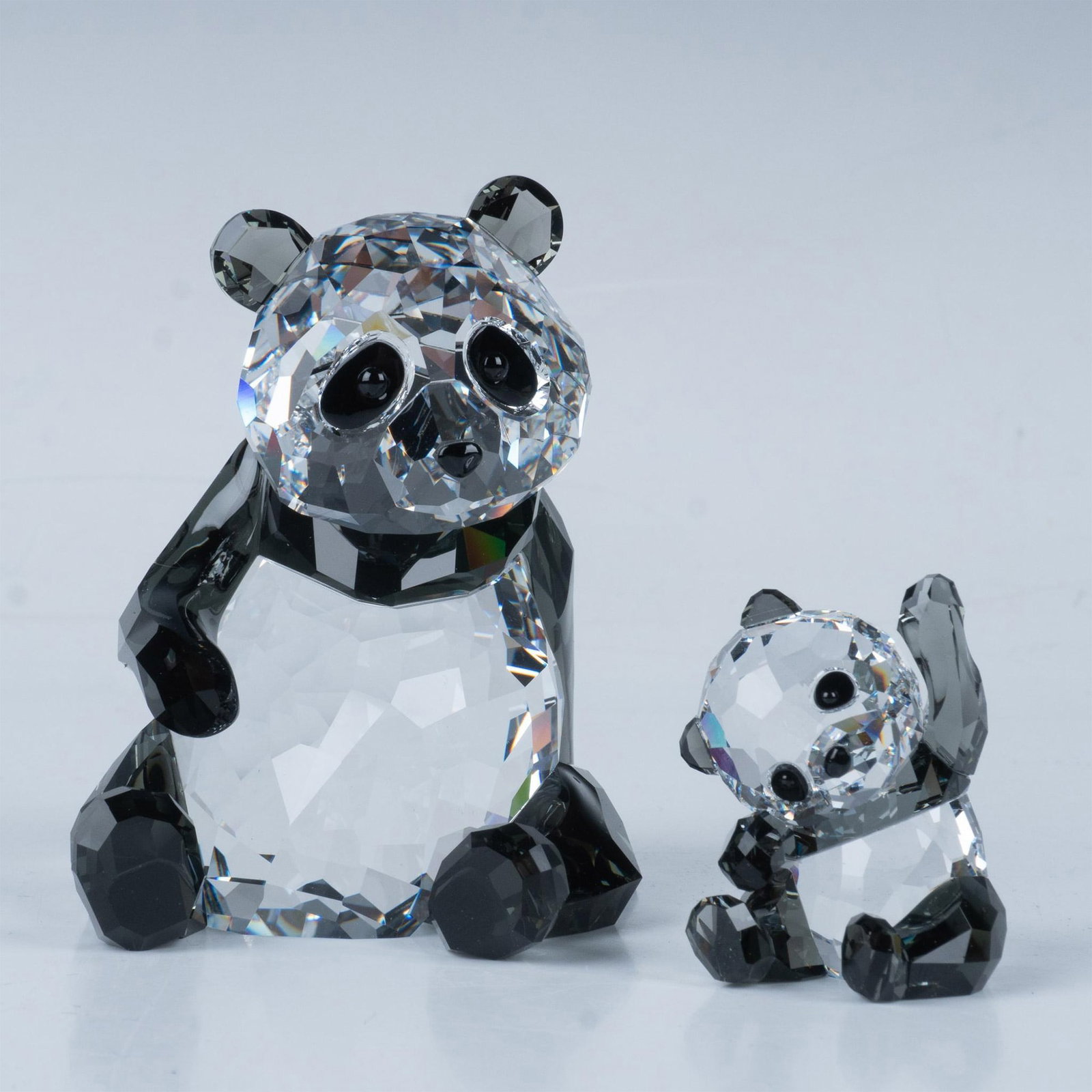 Swarovski Crystal Figurine, Panda Mother with Baby: This pair of panda bears feature a beautiful panda bear mom in a relaxed position and her little baby waving. Engraved signature. This item has its original box. Box measures: 6.75"L x 6.75"W x 4.75"H