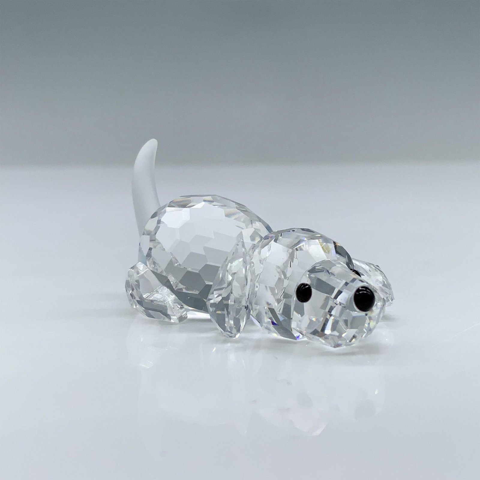 Swarovski Crystal Figurine, Beagle Puppy Playing: Part of the Peaceful Countryside theme group. An adorable clear crystal puppy in a prone position ready to play. Frosted tail, and black eyes and nose. Swarovski swan marked. This item has its origina
