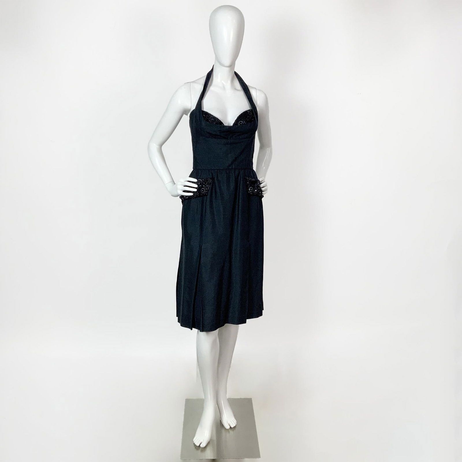 Original Bruce Oldfield Black Silk Sleeveless Cocktail Dress: Original Bruce Oldfield black silk sleeveless cocktail/evening dress with halter neckline. Includes black beaded embroidery on bustier cups and on the faux front pockets pleats. Label: Bruce Oldfield