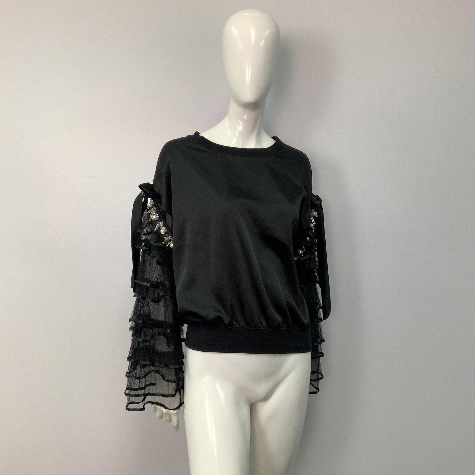 Belulah Black Embellished Ruffled Sleeves Sweater: A relaxed black sweater featuring ruffled sleeves, decorated with beads and faux pearls, and finished with big bows on the shoulders. Size: L. Bust: 22"W. Sleeve length: 19.5"L. Full length: 21"L. All