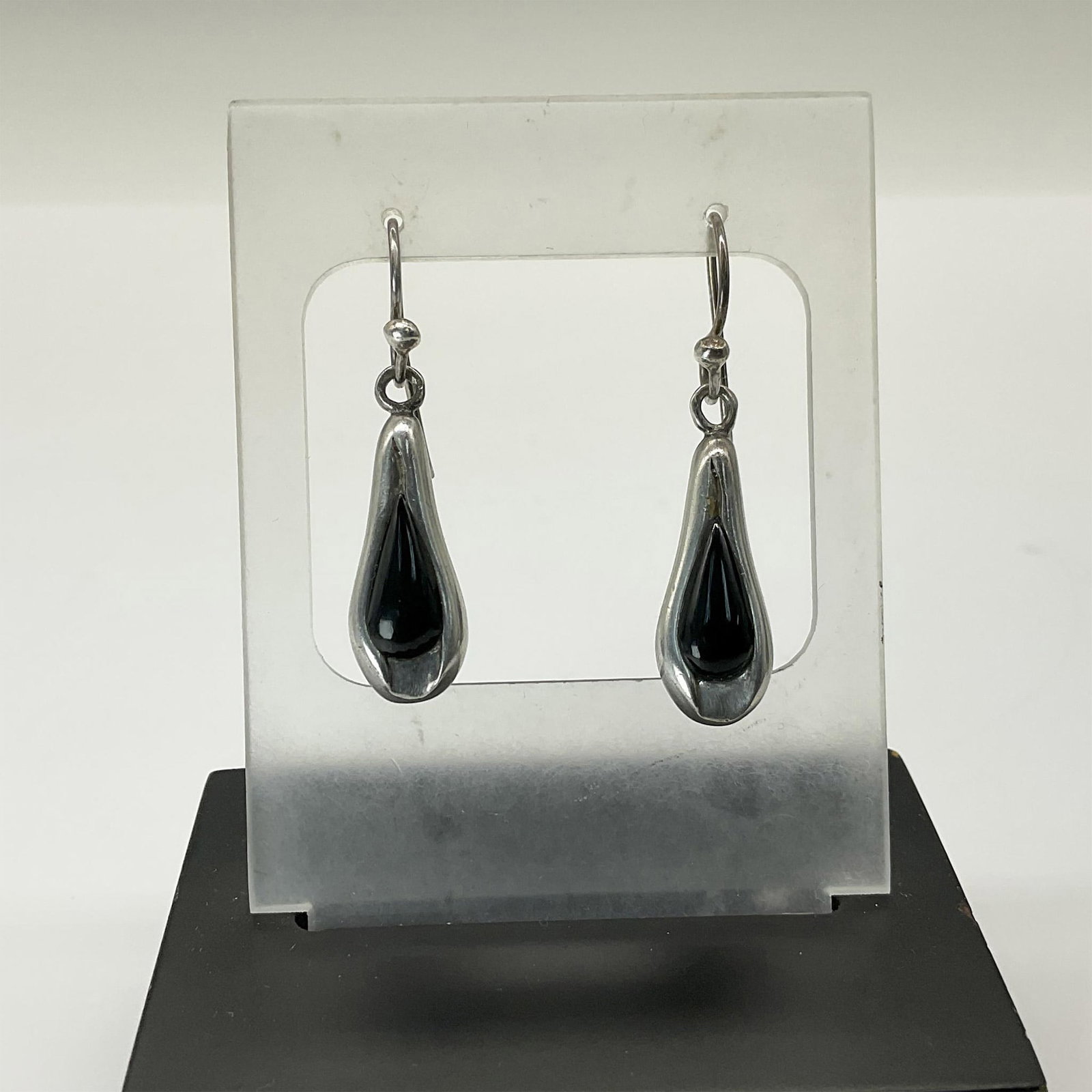 Barse Sterling Silver Hanging Earrings: Teardrop shaped sterling silver earrings adorned with a black teardrop shaped stone. Marked 925. Hanging from a curved hanging wire. Total weight 8 grams. Dimensions: 0.5"W x 1.5"H