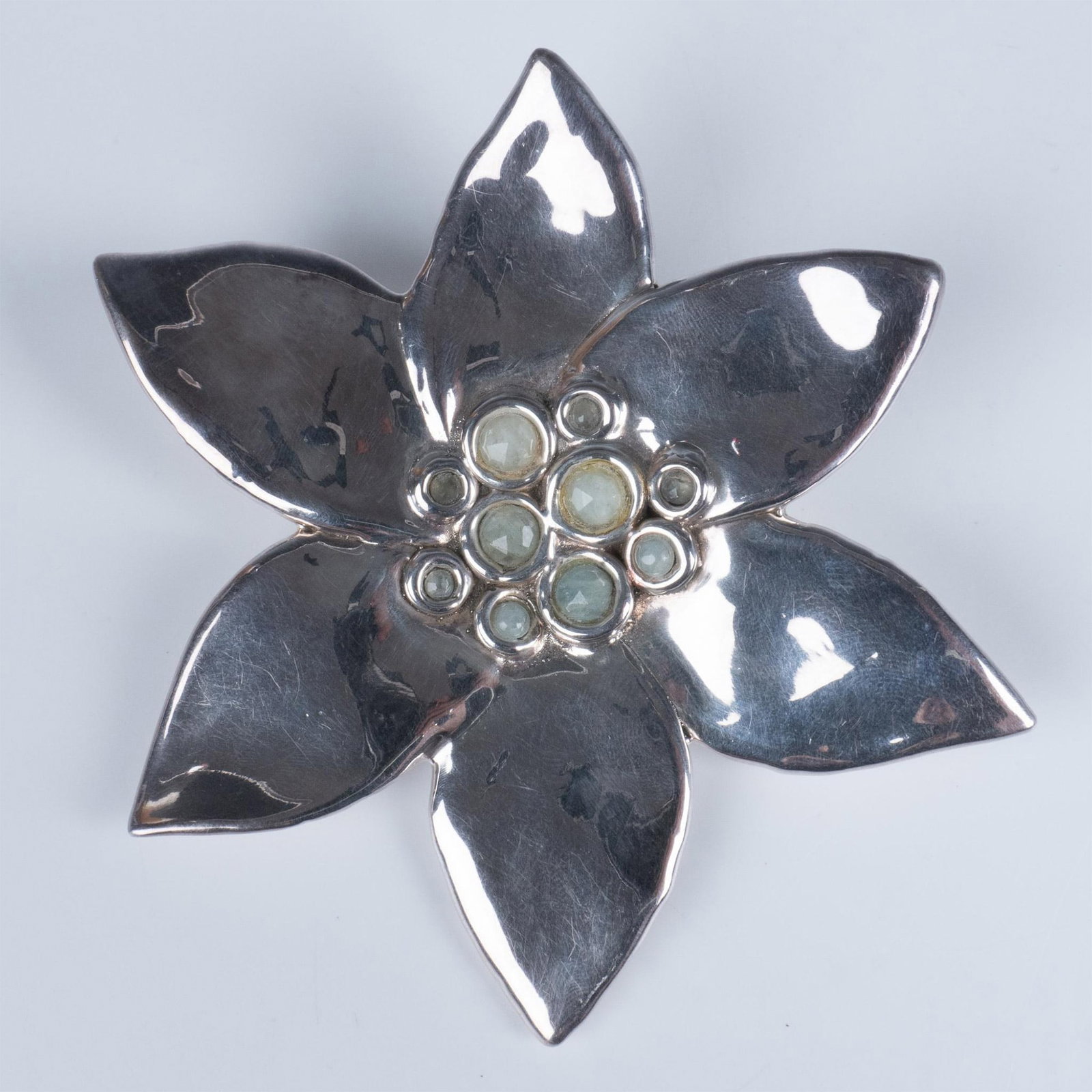 Sterling Silver Flower Pendant Brooch Pin: Fabulous sterling silver flower with gemstones set in the middle. It features both a pin and bail so it can be worn as a brooch or necklace. It is stamped 925 on the back with an illegible hallmark. D