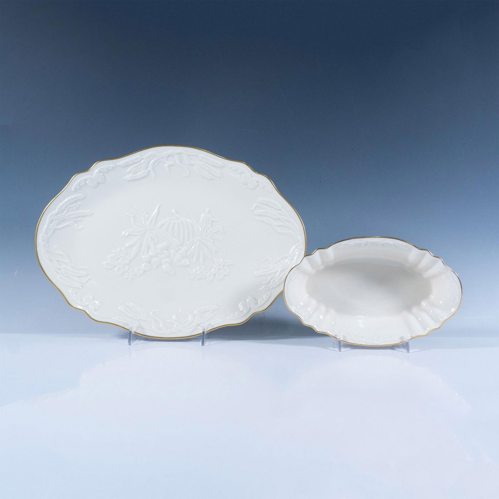 2pc Lenox Porcelain Serving Platter and Bowl, Harvest: Two cream colored porcelain serveware table items decorated with vegetables and wheat in low-relief; gold rims. Oval serving platter 14"L x 10.75"W x 1"H. Oval bowl 8.5"L x 5.25"W x 2.25"H. Lenox back