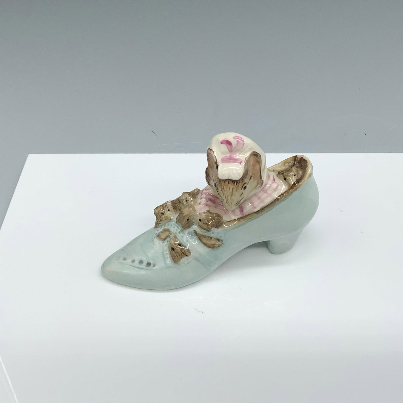 Old Woman Who Lived in a Shoe - Royal Albert - Beatrix Potter Figurine: Glossy porcelain figurine of a rodent mom with her many children. Royal Albert Beatrix Potter backstamp. This item has its original box (3"L x 3"W x 4.25"H). Issued: c. 1989 Dimensions: 3.75"L x 1.25"