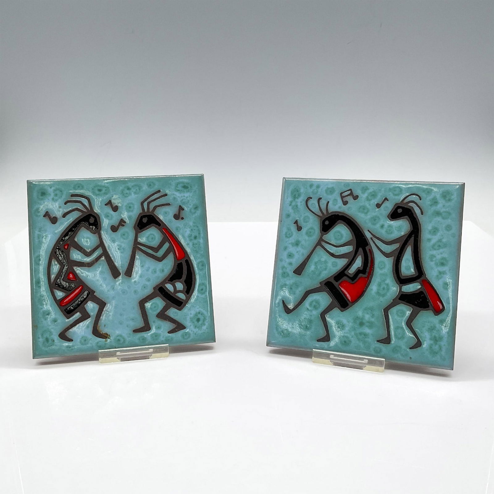 2pc Teissedre Designs Enameled Kokopelli Tiles: Handcrafted colorful Southwestern designed enameled tiles with flute player colored in turquoise, red and black. Tiles designed can be used as coasters, trivets but are designed beautifully enough to
