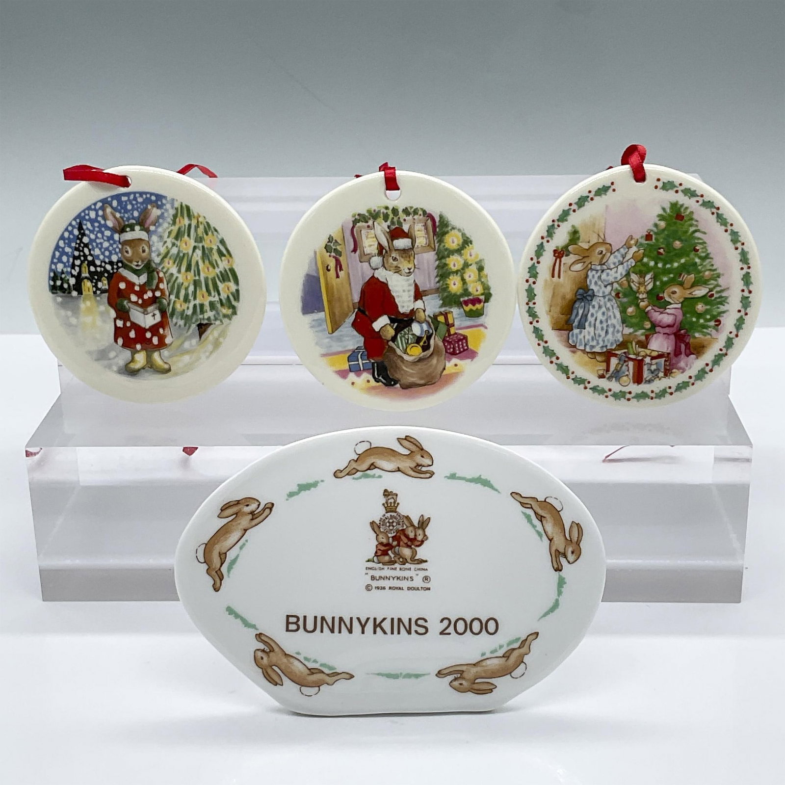 4pc Royal Doulton Bunnykins Bone China Plaque and Ornaments: A charming Bunnykins set featuring 1 special edition plaque and 3 delightful Christmas ornaments. The plaque, marked Bunnykins 2000, is one of only 1,250 pieces created. The ornaments are each a beaut