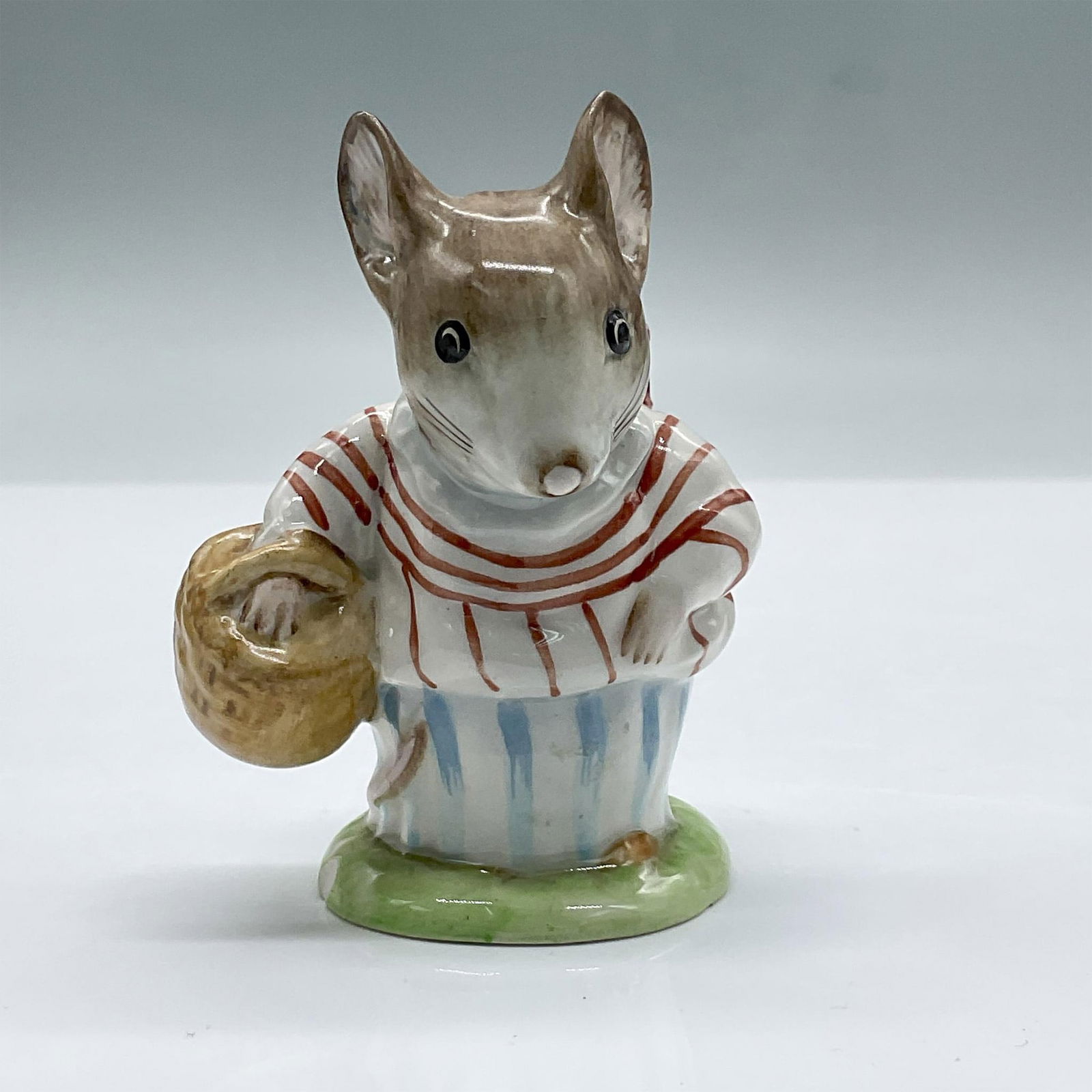 Beswick Beatrix Potter Gold Oval Figurine, Mrs Tittlemouse: Features a glossy porcelain mouse carrying a basket. Beswick Beatrix Potter backstamp. Gold Oval Backstamp. Issued: 20th century Dimensions: 2.5"L x 2.5"W x 3.5"H Manufacturer: Beswick Country of Orig