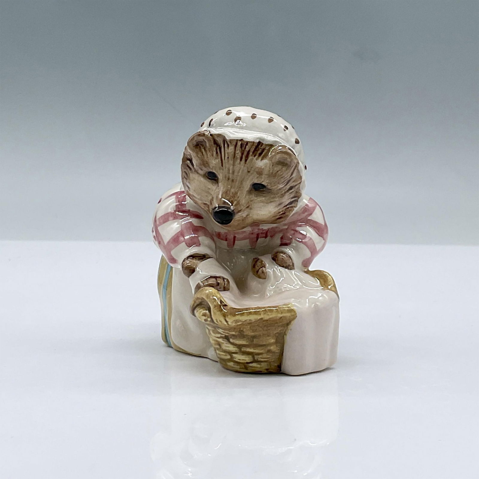 Beswick Beatrix Potter Figurine, Mrs Tiggy Winkle: Glossy porcelain. Features Mrs Tiggy Winkle Washing. Beswick, Royal Doulton and F Warn & Co. Beatrix Potter copyright backstamp. This item has its original box, dimensions: 3"L x 3"W x 4.5"H. Issued: