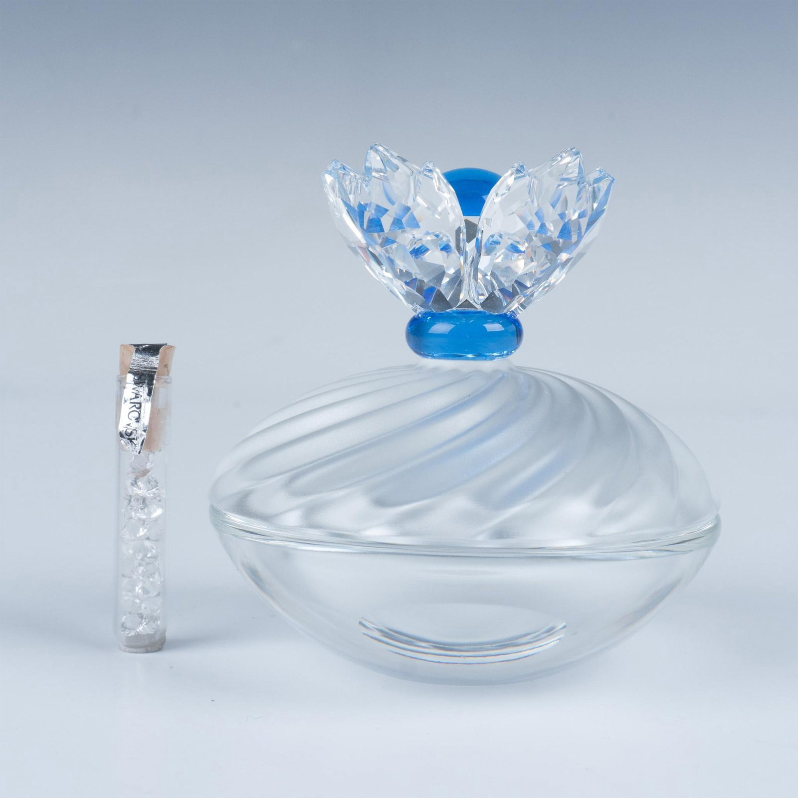Swarovski Crystal Blue Flower Jewel Box: Stunning treasure box with a clear crystal base and a frosted crystal for the lid, showcasing a faceted flower on top with blue crystal features. This item has its original box. Box measures: 9.5"L x 