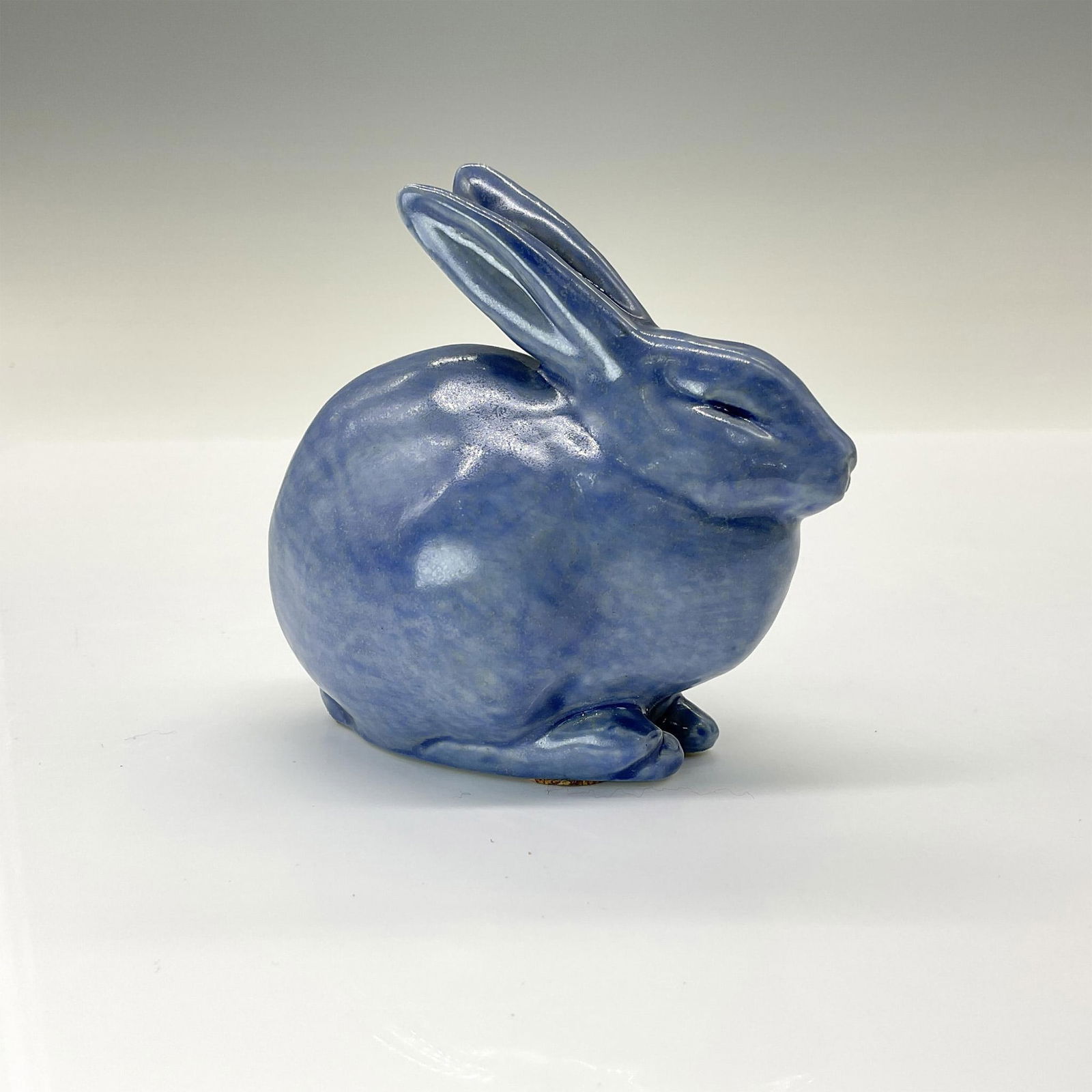 Rookwood Present Day Pottery Animal Figurine, Blue Rabbit: Adorable crouched rabbit crafted from the original master mold #6160 from 1928. Finished in a lovely blue glossy glaze. Rookwood backstamp. This item has its original box that measures 5.5"L x 4"W x 3