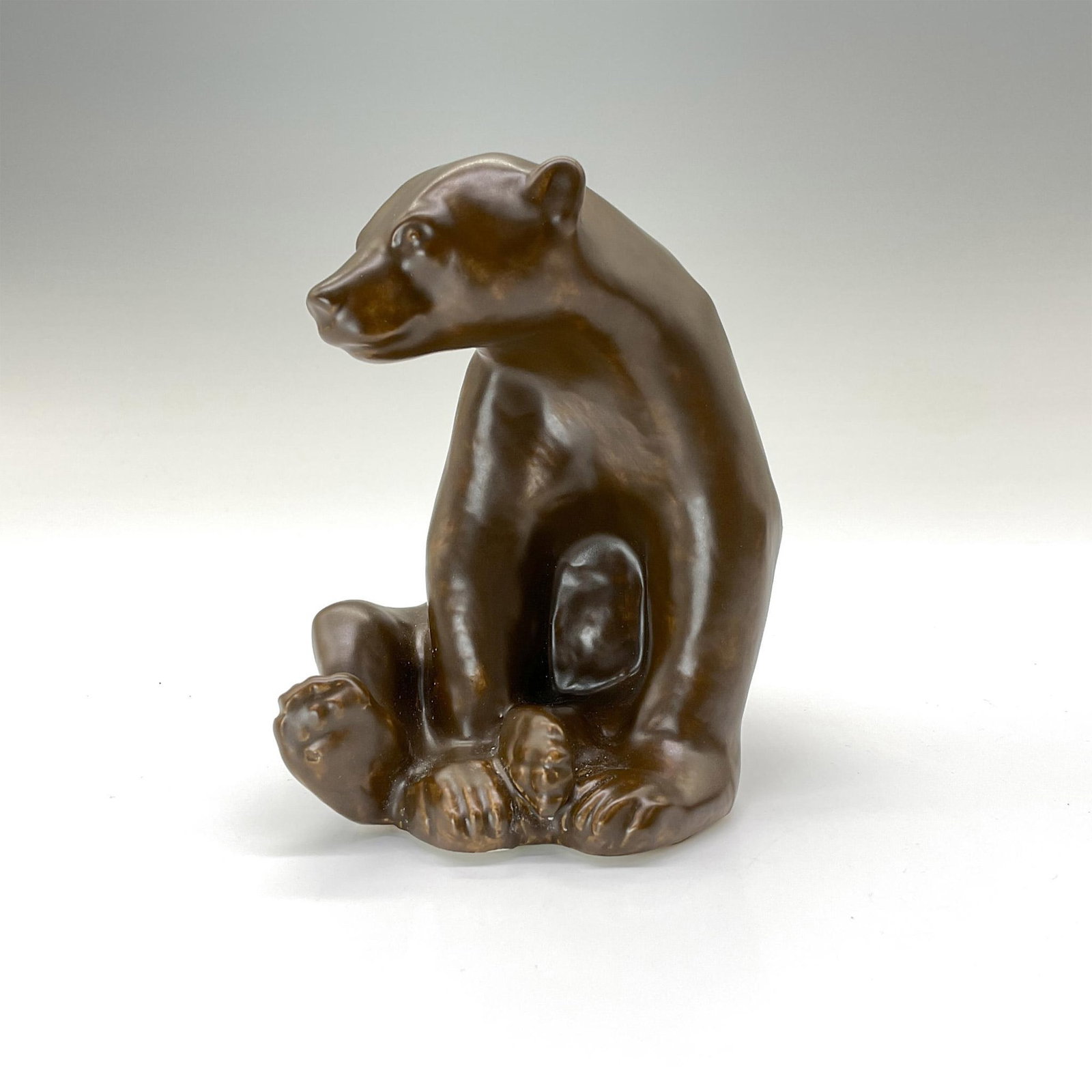 Rookwood Present Day Pottery Animal Figurine, Brown Bear: Charming seated bear crafted from the original master mold #6485 from 1945. Finished in a soft chocolate-brown semi-matte glaze. Rookwood backstamp. This item has its original box that measures 5.75"L