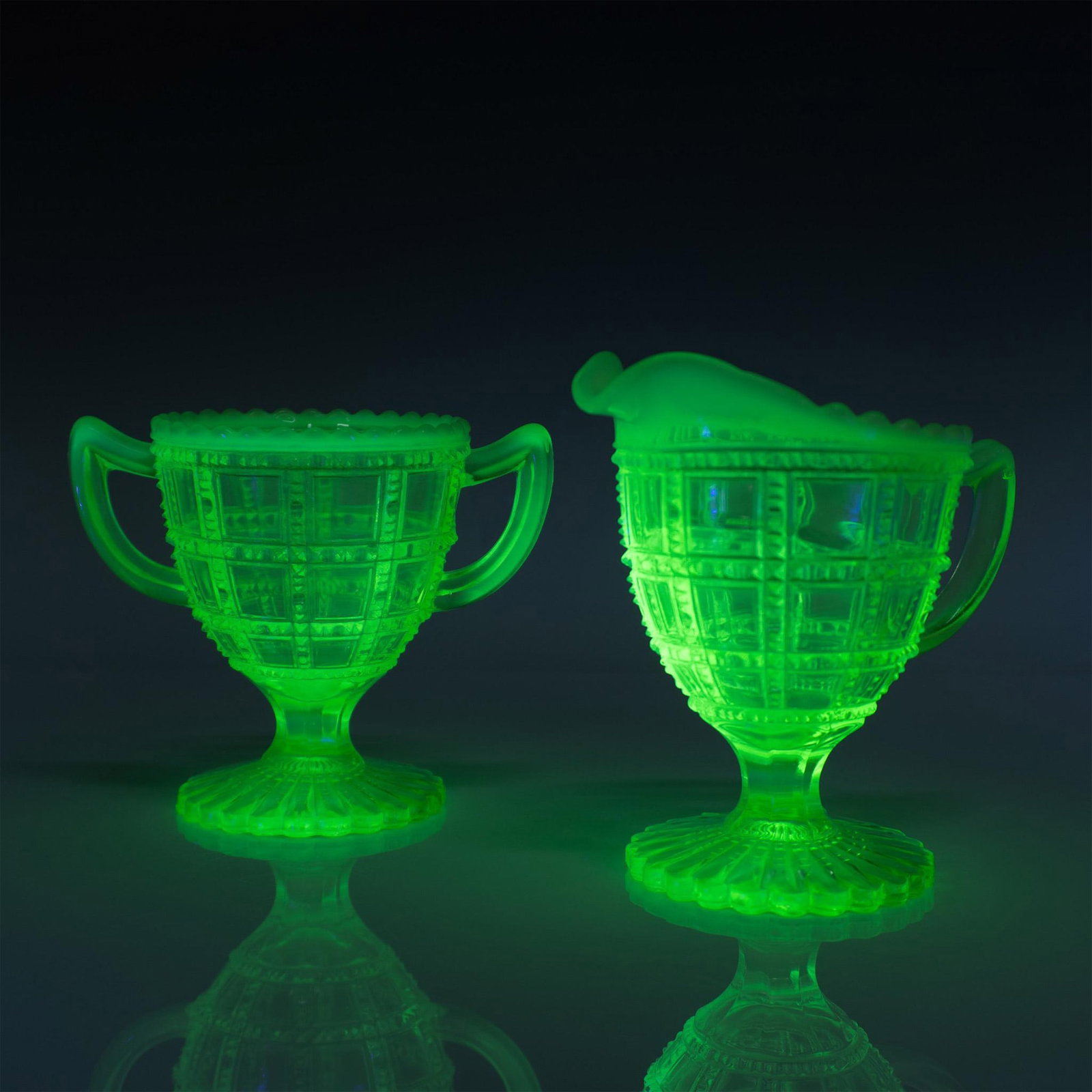 Opalescent Green Footed Creamer and Sugar Uranium Glasses: This vintage set features a beaded block uranium glass design. Largest measures 4.75"L x 3.5"W x 5"H. Issued: 20th century Dimensions: See Description