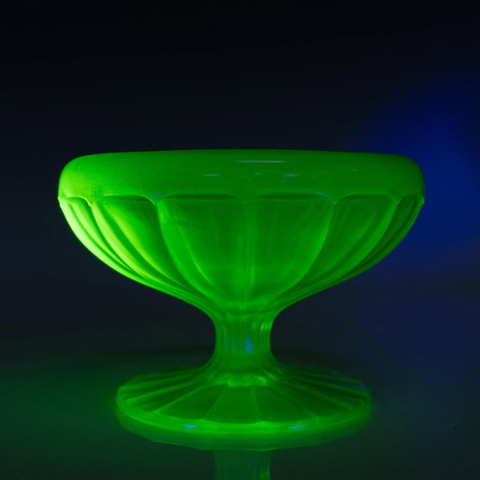 Fenton Uranium Glass Footed Candy Bowl, Green Carnival: Stunning Art Deco design featuring a greenish-yellow piece with a captivating rainbow-like reflective finish. Issued: 20th century Dimensions: 3.5''H x 5''dia Manufacturer: Fenton Country of Origin: U