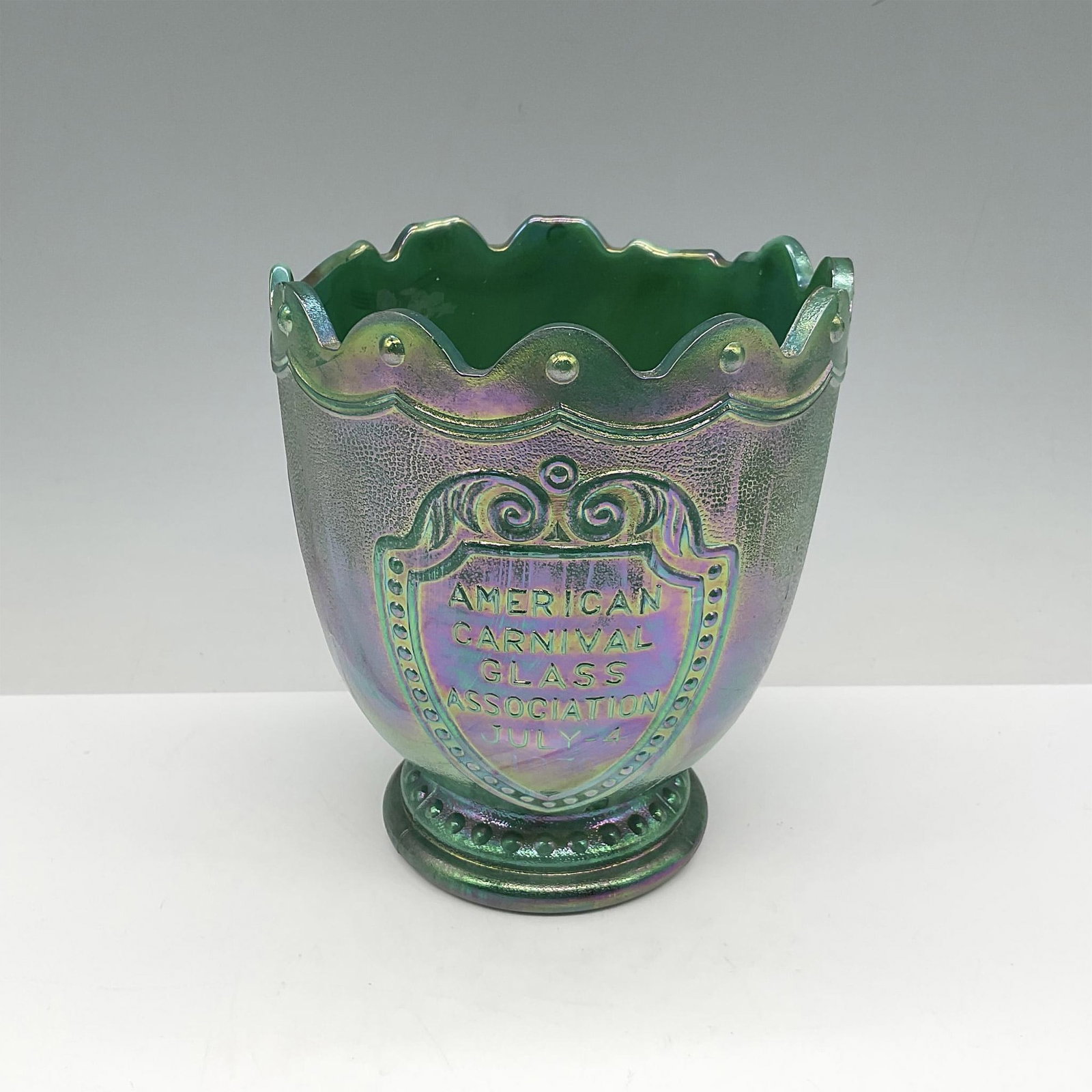American Carnival Glass Commemorative Indianapolis 500: Green iridescent carnival glass made in the form of a trophy with raised lettering for ACGA and celebrating the 500 race held July 4th. Issued: c. 1970 Dimensions: 5.5"H x 4.5" dia, Country of Origin: