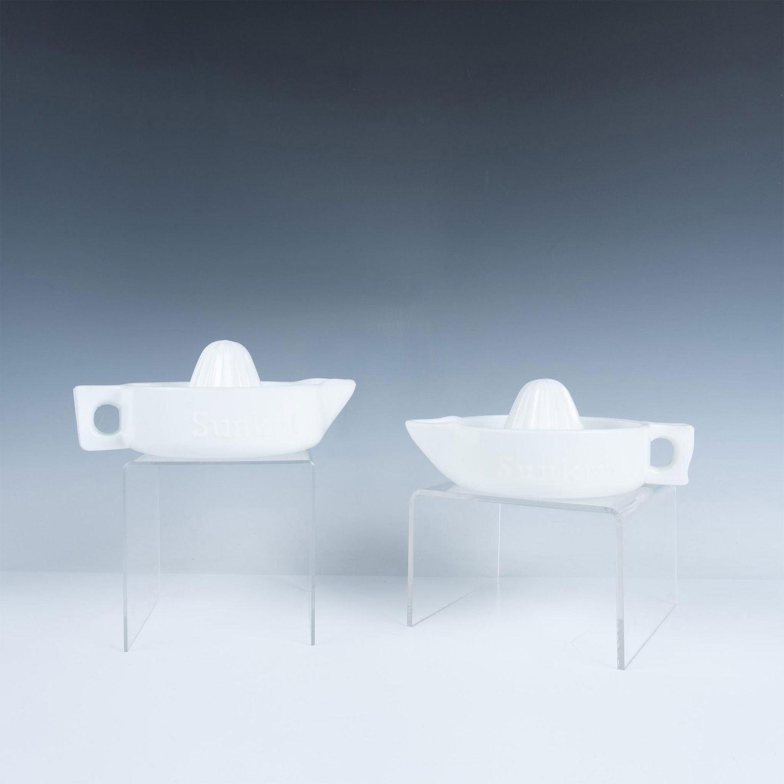 2pc Sunkist Milk Glass Juicers Reamers: A charming pair of milk glass juicer reamers, each featuring a lovely handle and spout Marked Sunkist. Marked USA. Dimensions of the largest item: 8.25"L x 6.25"W x 3.5"H. Dimensions: See Description