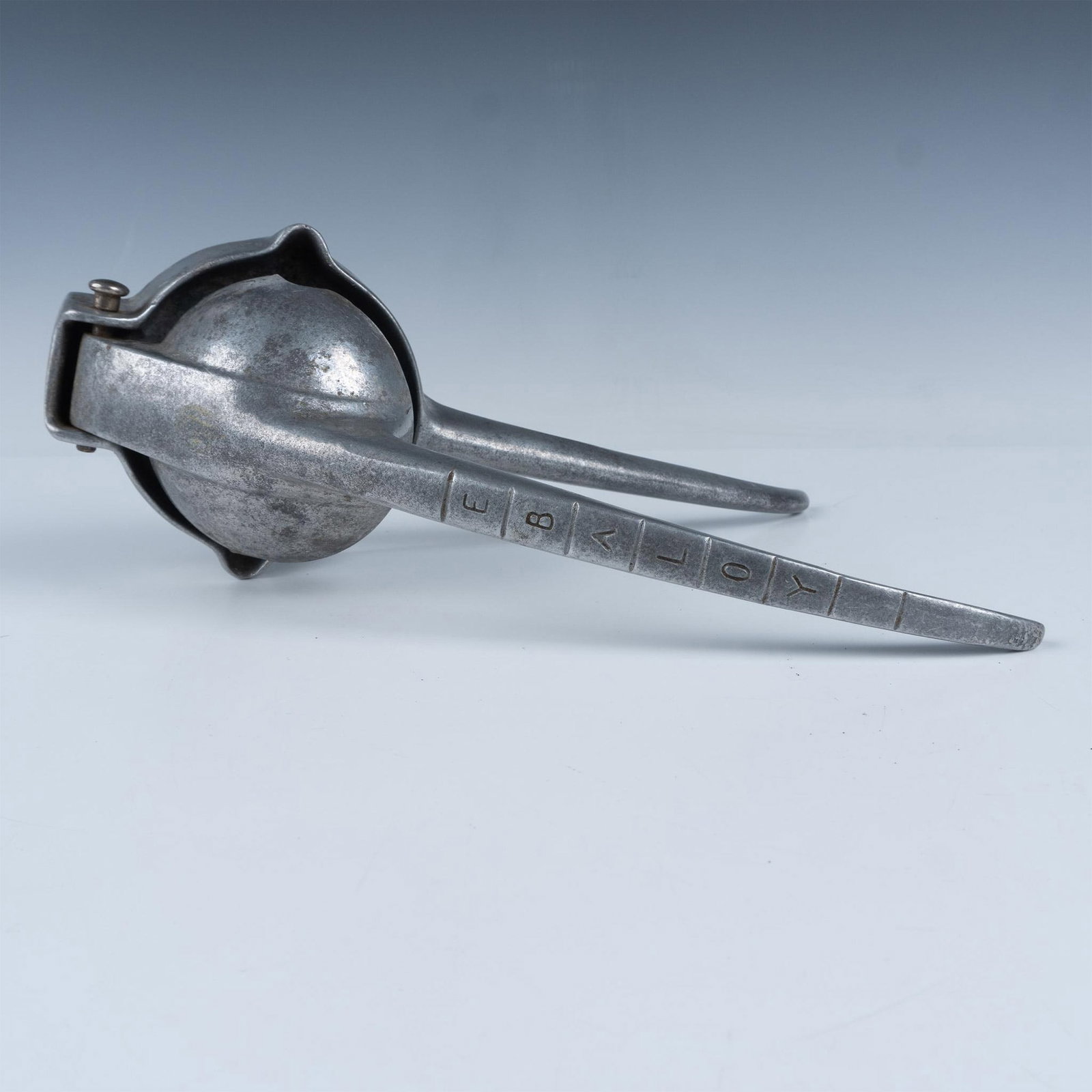 Ebaloy Aluminum Hinged Juicer: Handheld, bottom has two pouring spouts on opposite sides. Ebaloy Inc. engraved mark. Issued: 20th century Dimensions: 12.5"L x 5"W x 2.25"H Manufacturer: Ebaloy Inc. Country of Origin: United States