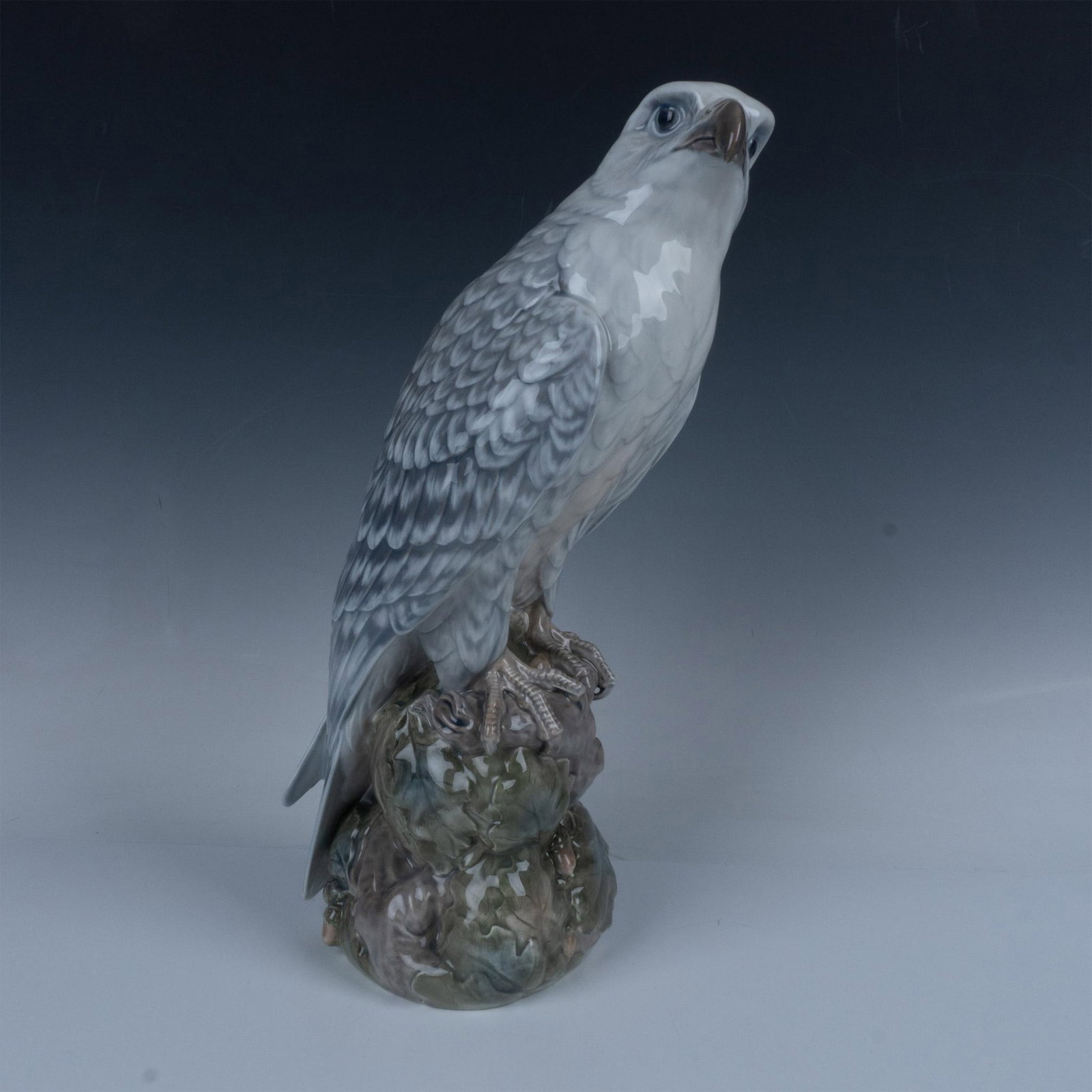Royal Copenhagen Porcelain Figurine, Icelanding Falcon 1661: Rare piece, designed by Peter Herold (1879-1920) for Royal Copenhagen. Features a majestic bird in a rocky base. Royal Copenhagen backstamp. Artist: Peter Herold Issued: 20th century Dimensions: 7.5''