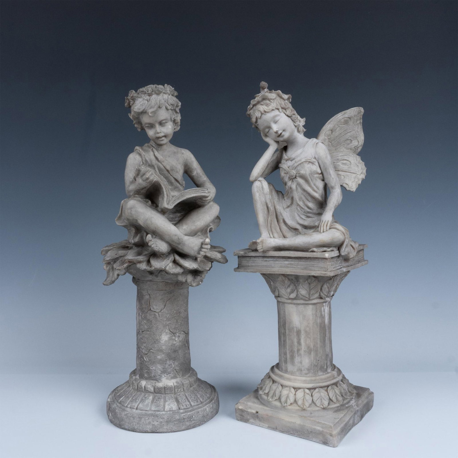 2 Classic Garden Nymph Statues: Fantastic duo of statuettes that includes a robed child sitting on a sunflower scrolling through a book, and a fairy with a leaf hat who is also sitting down. Largest item measures 5"L x 5.5"W x 15.75
