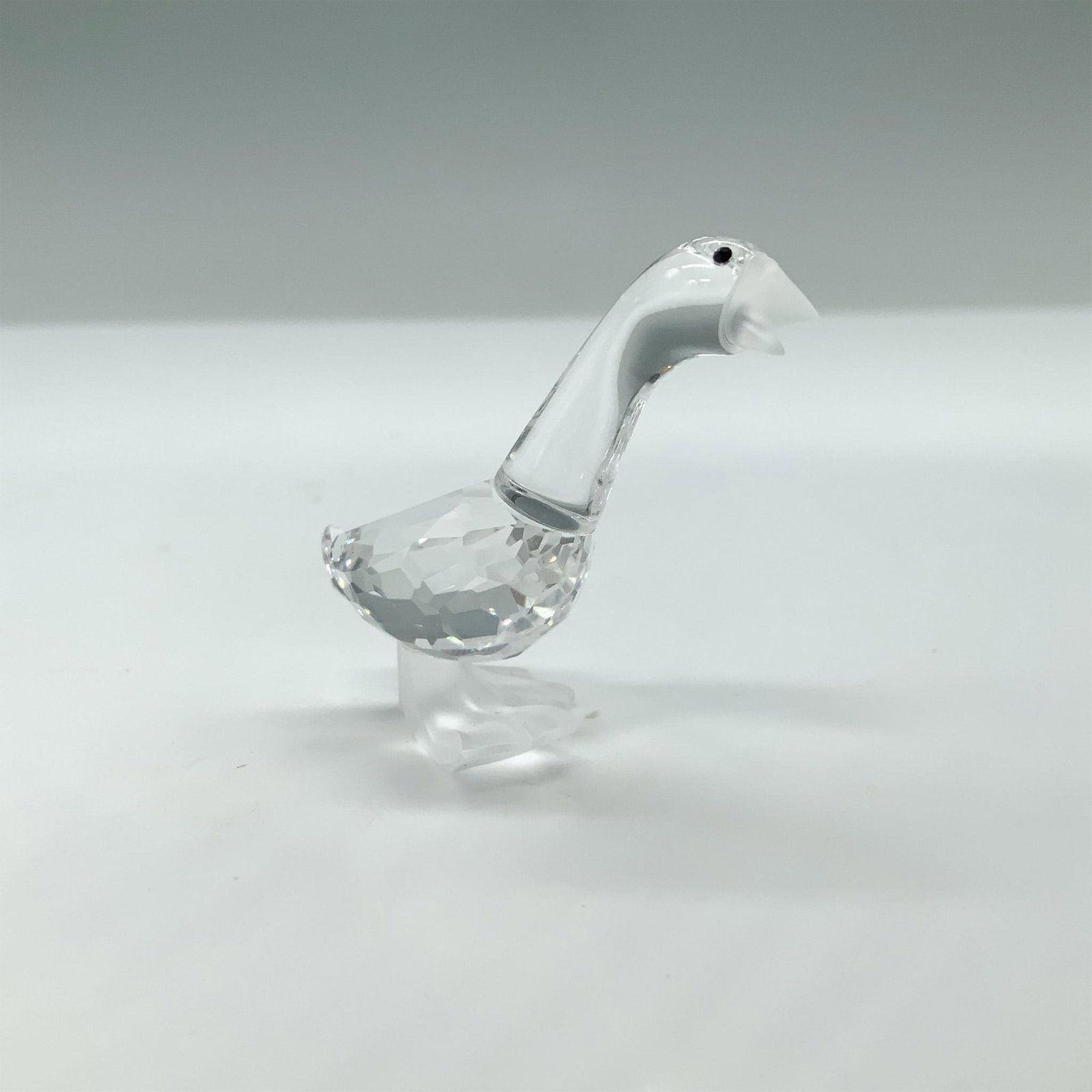 Swarovski Crystal Figurine, Gosling Dick: Charming little dick gosling made of facetted crystal with black eyes. The beak and feet are in frosted crystal. This item has its original box. Box measures: 2.5"H x 3.25" dia. Swarovski swan mark. 1